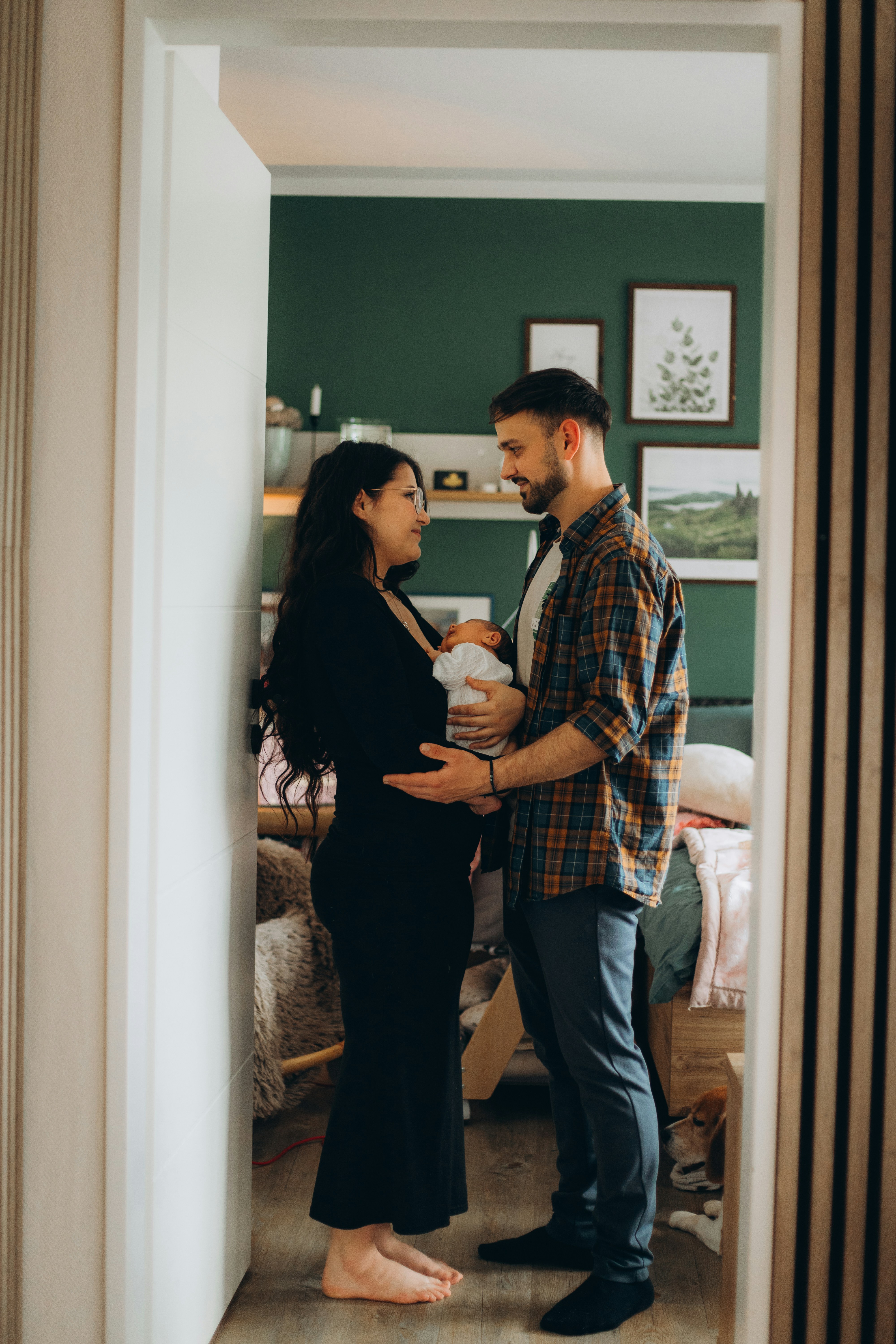 Una pareja amorosa sostiene a su bebé recién nacido en una habitación.