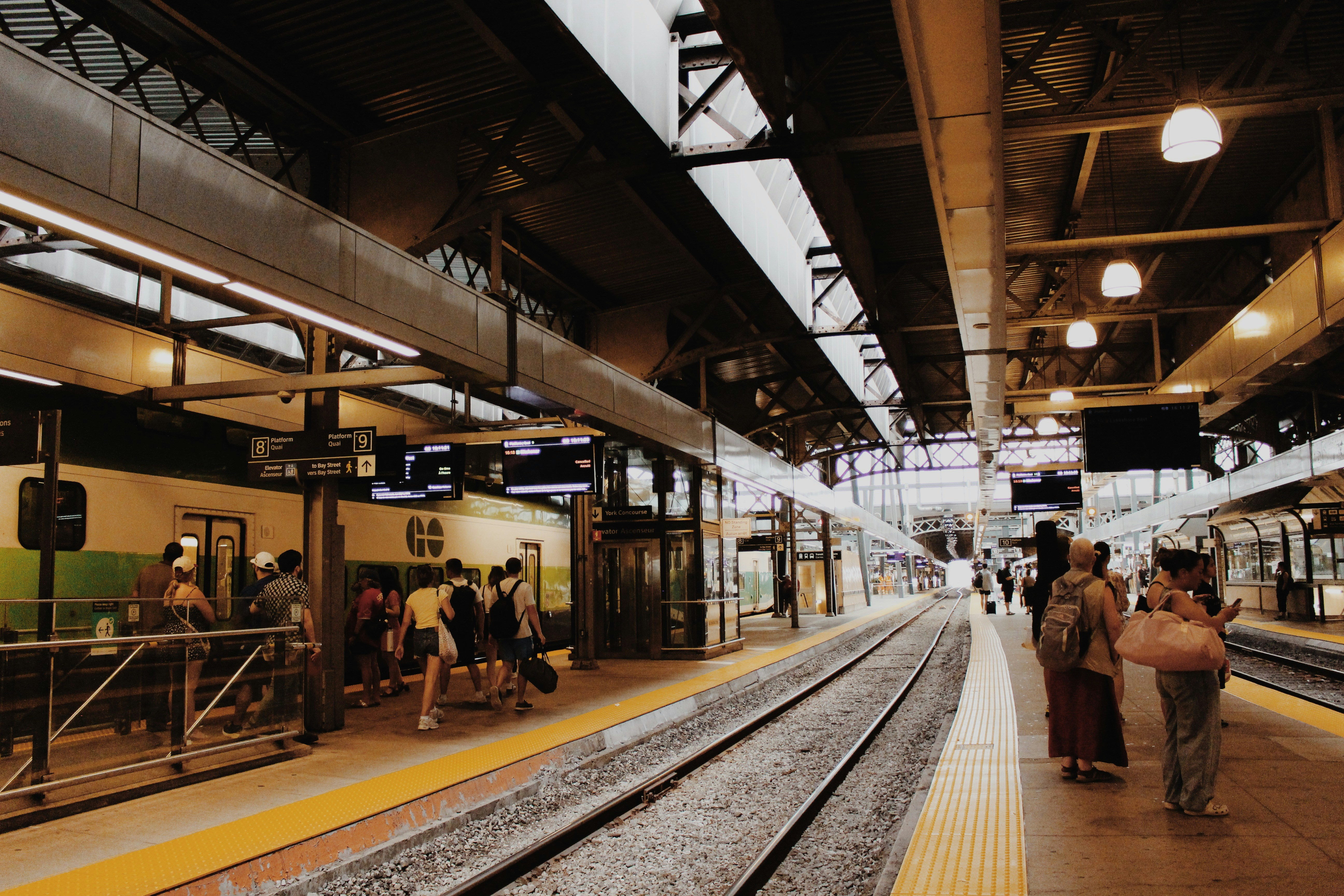 People waiting on a train station platform with a train.