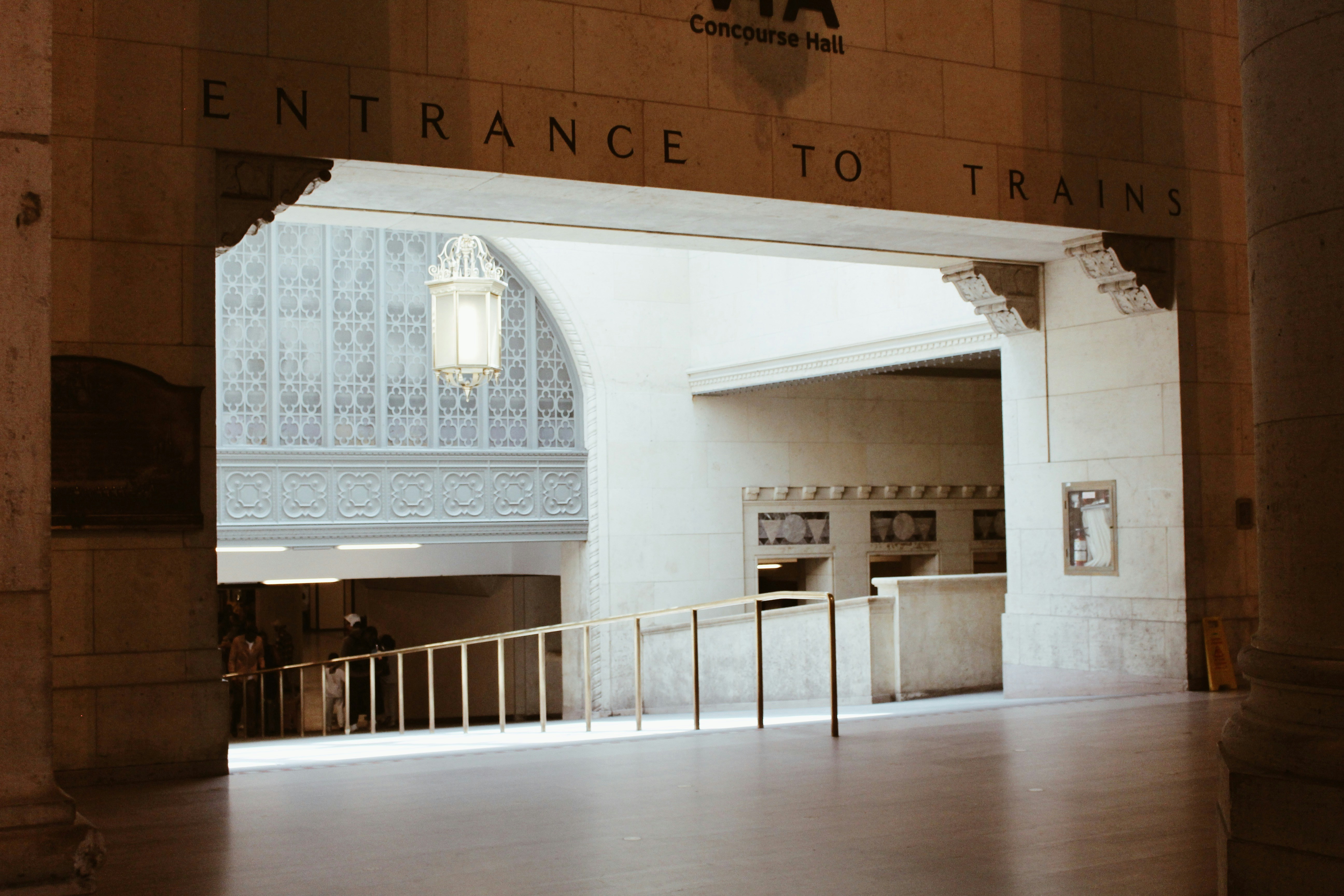 An archway entrance to trains with stairs and a counter.