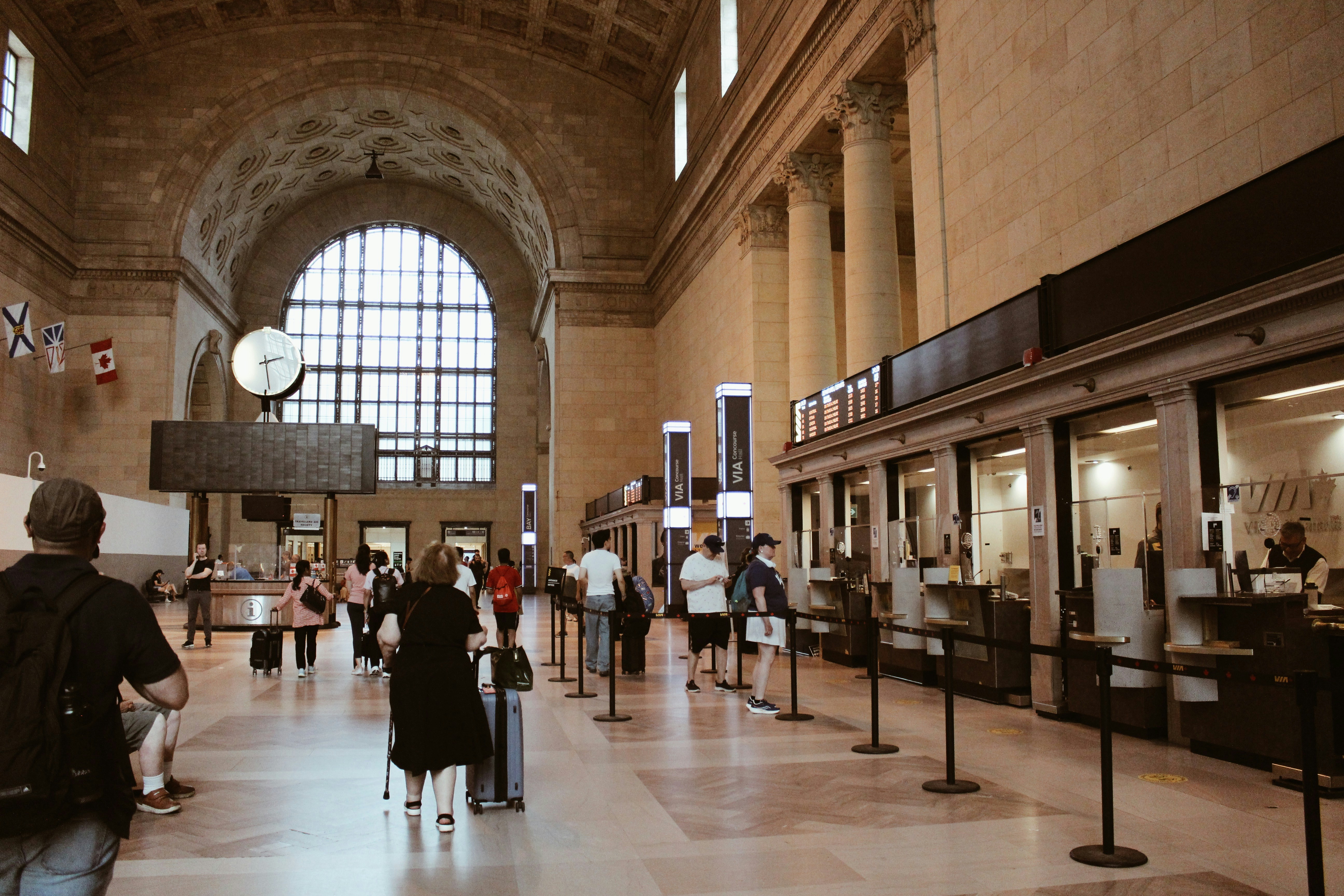 People walking in a grand, historic train station.