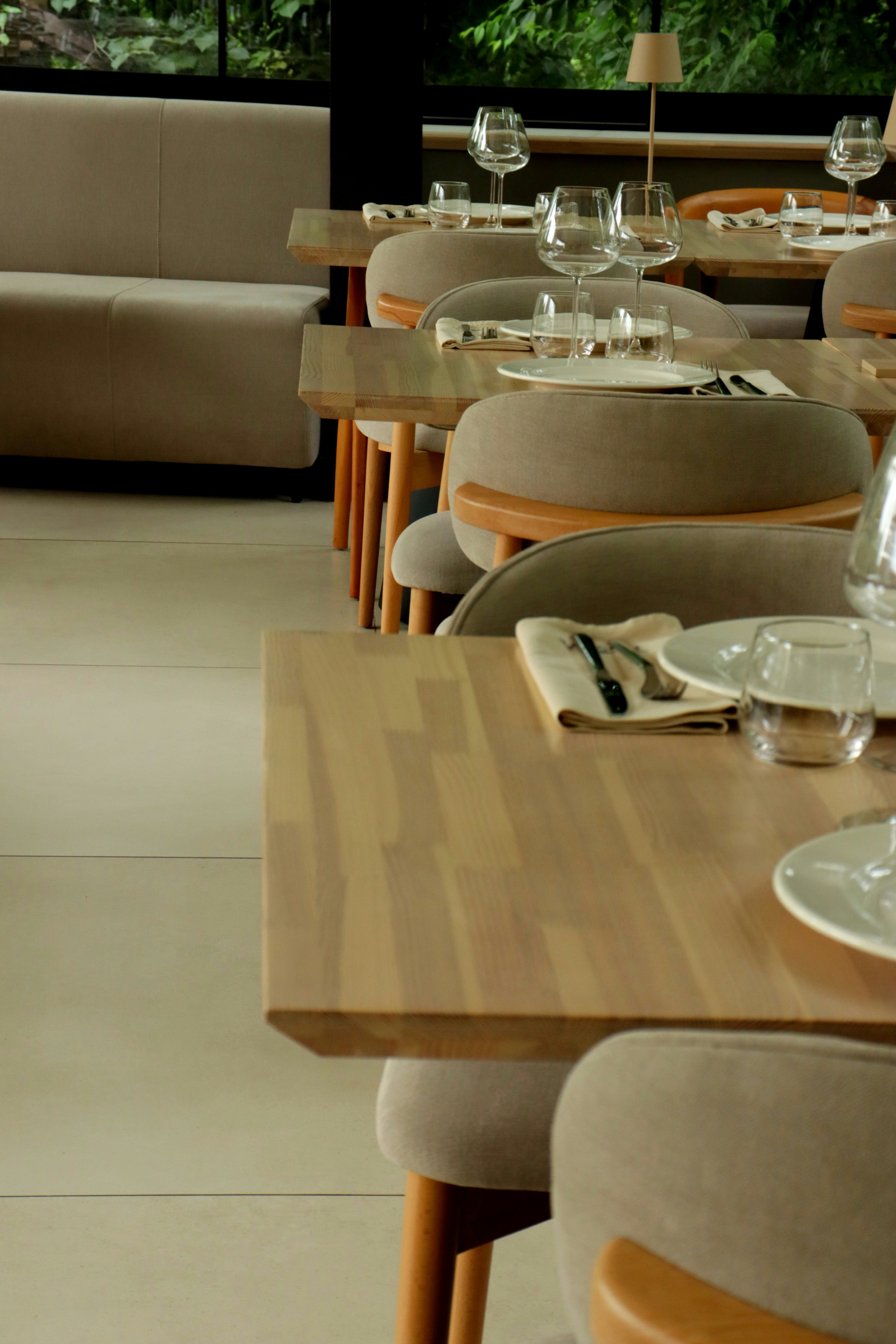 Un interior moderno de restaurante con mesas y sillas puestas.