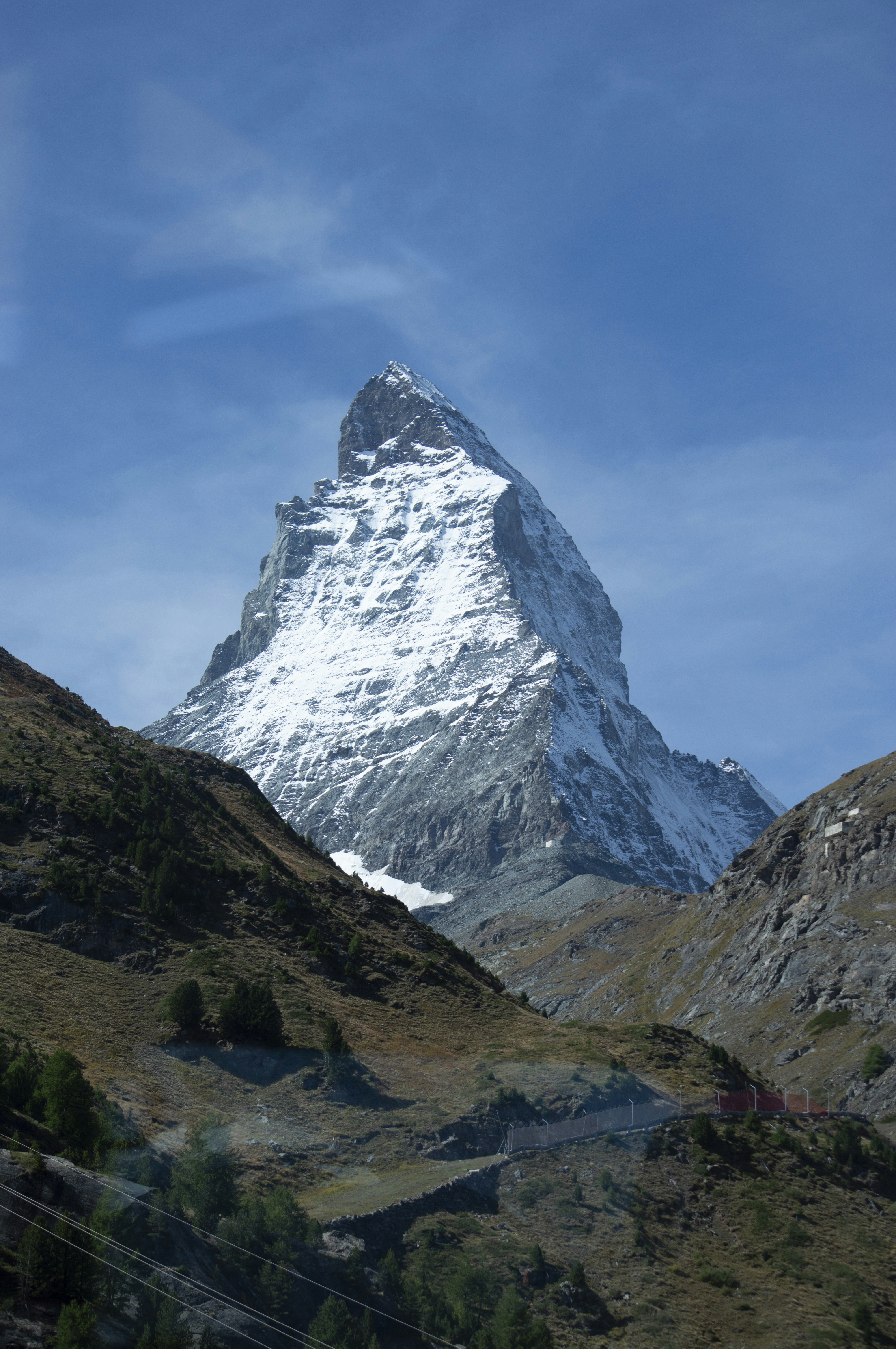 Snow-capped matterhorn mountain dominates a clear blue sky.