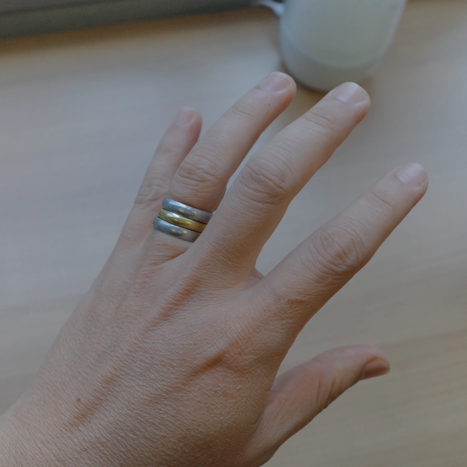 Three Terzo stacking bands in silver on one finger of a pale hand, in stock