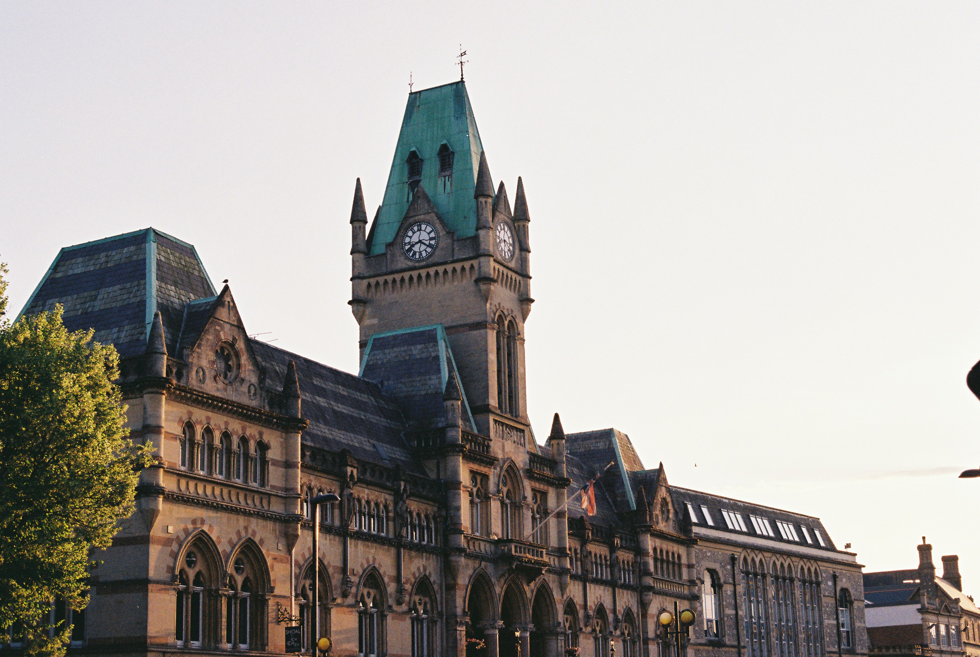 Victorian Gothic stone building with a green-roofed clock tower