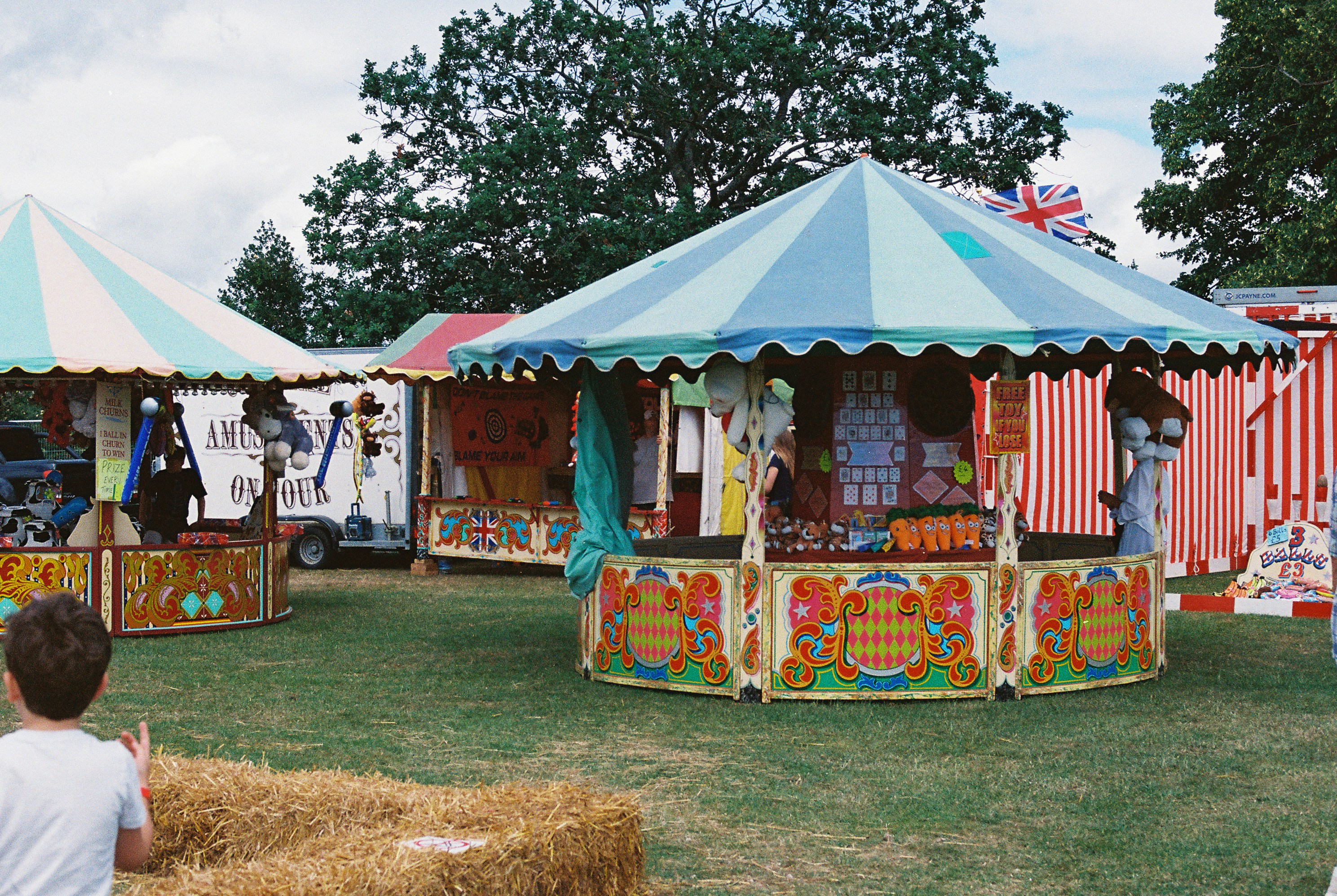 Striped fairground stalls on green grass