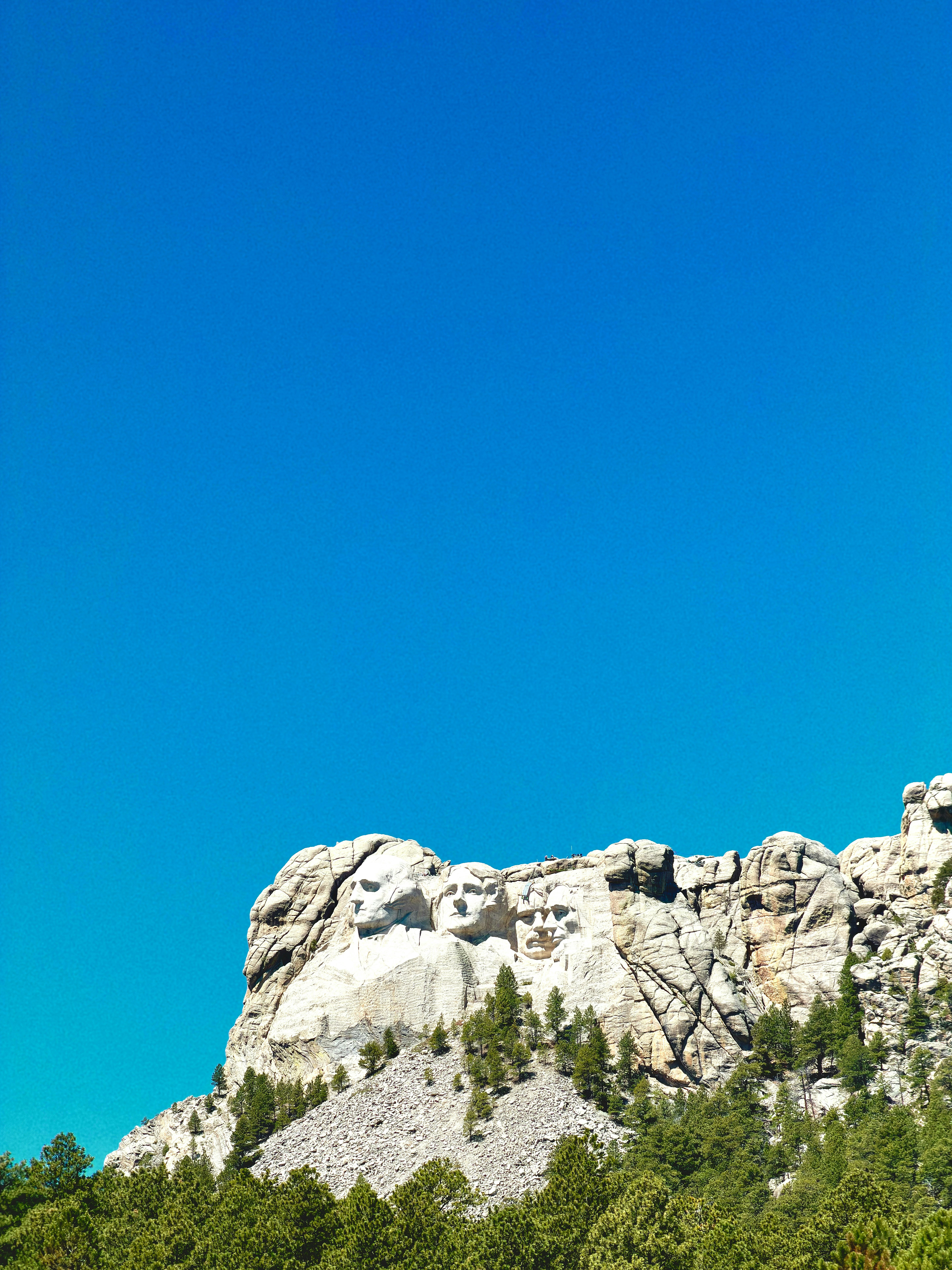 Monte Rushmore com entalhes presidenciais sob um céu azul claro