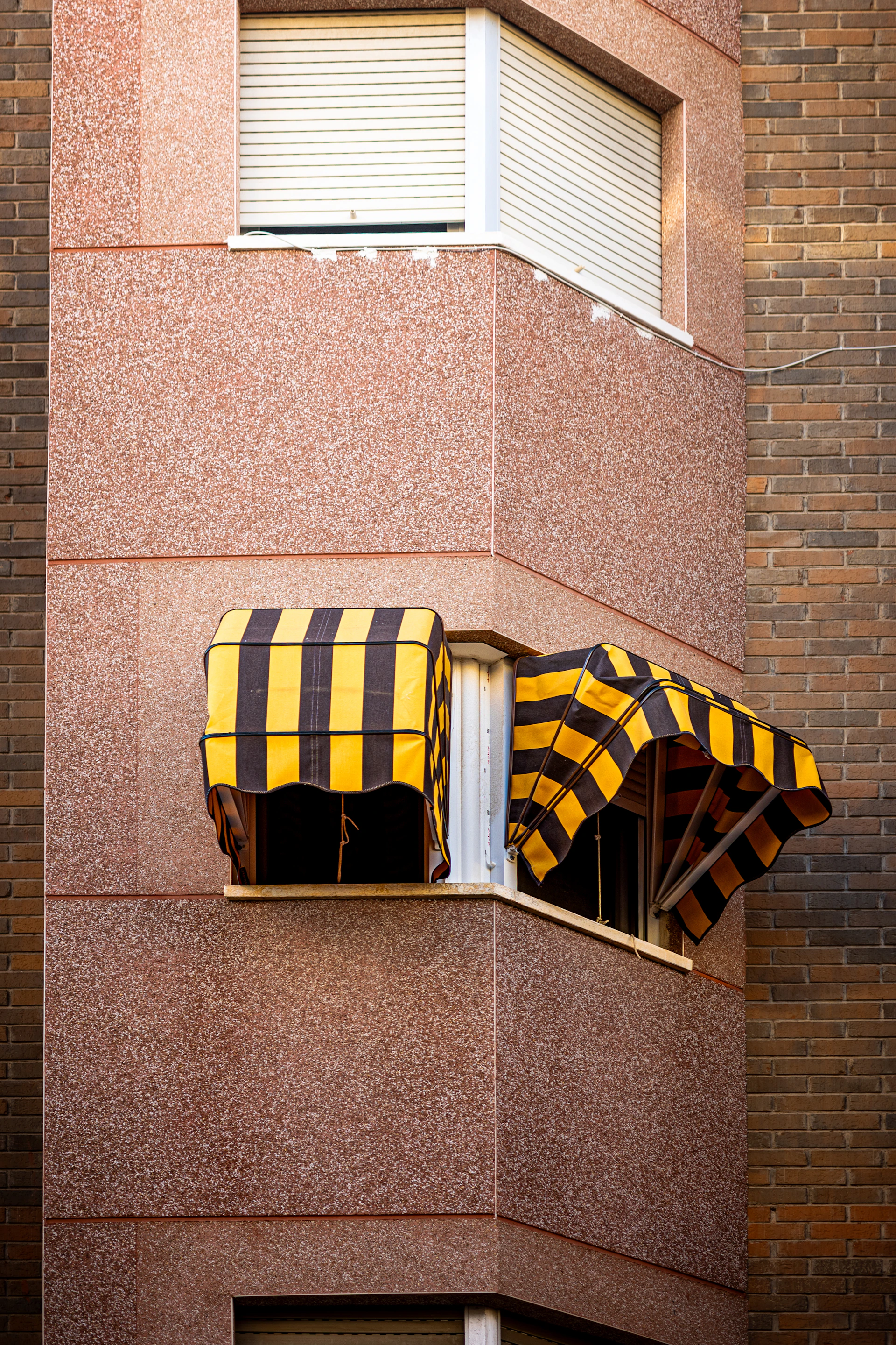 Yellow and black striped awnings on a building corner