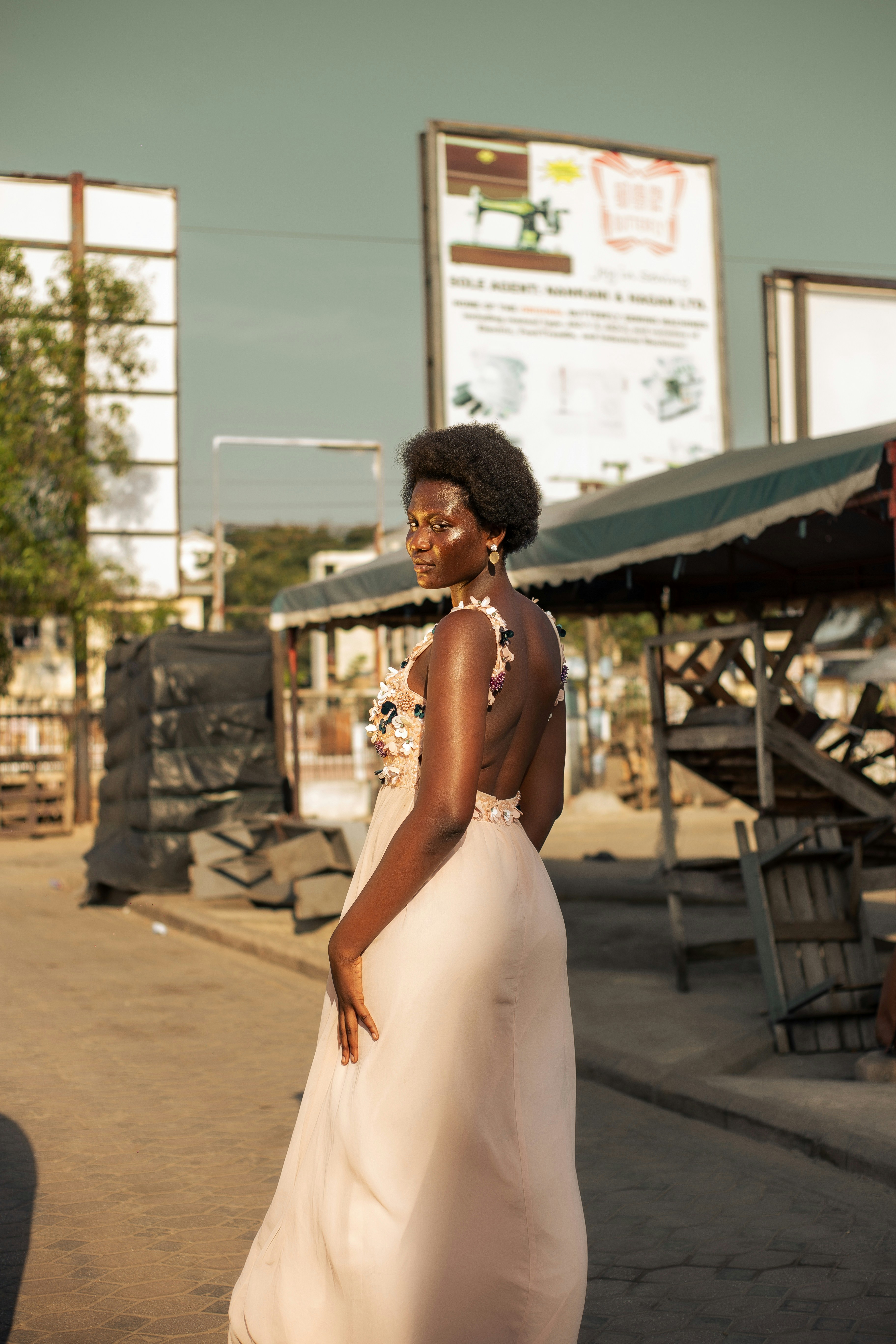 Woman in elegant backless gown looking over shoulder outdoors