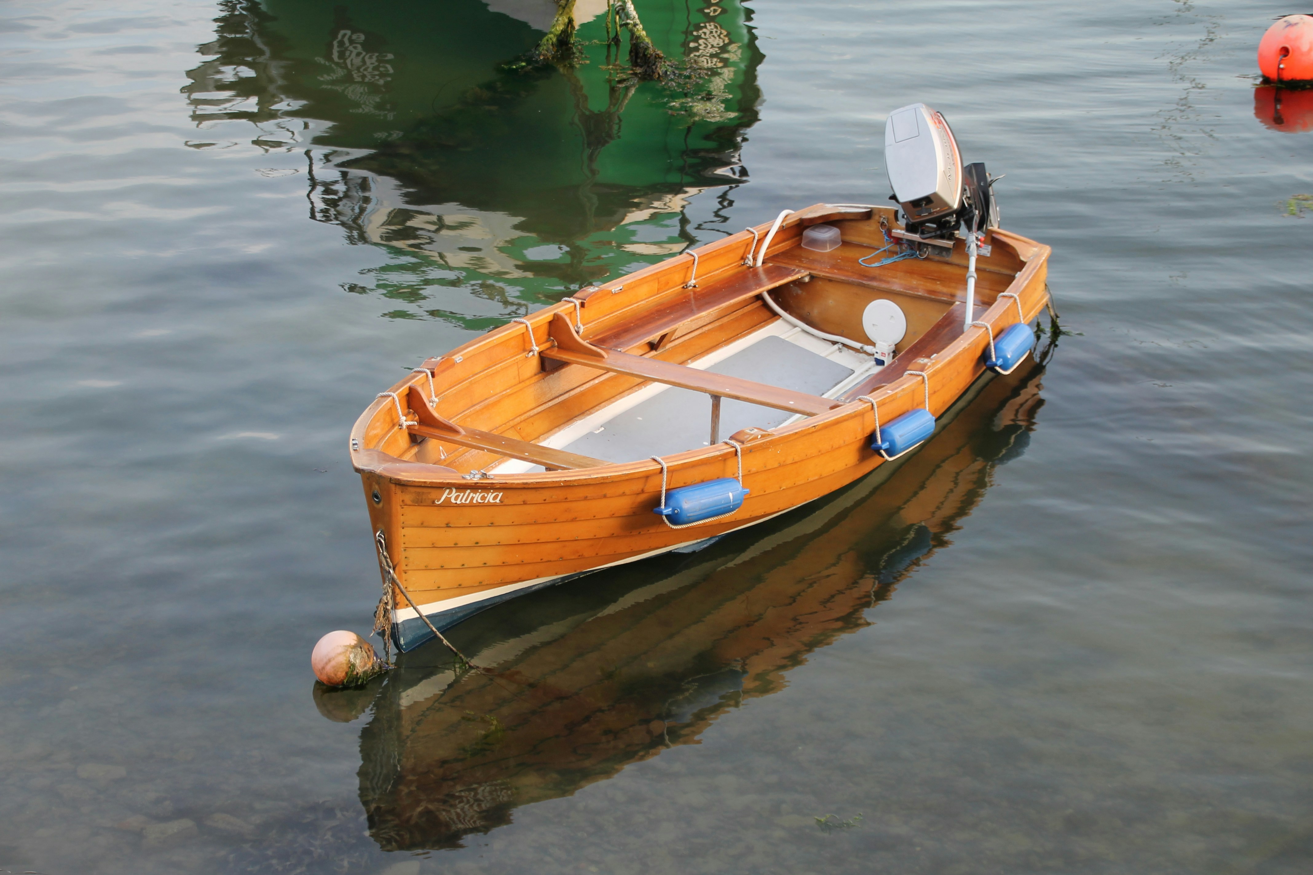 Una piccola barca di legno galleggia pacificamente su acque calme.