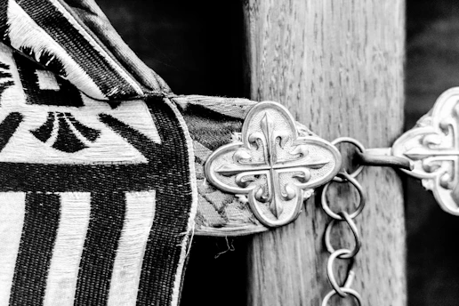 Decorative metal clasp on patterned fabric and wooden post.