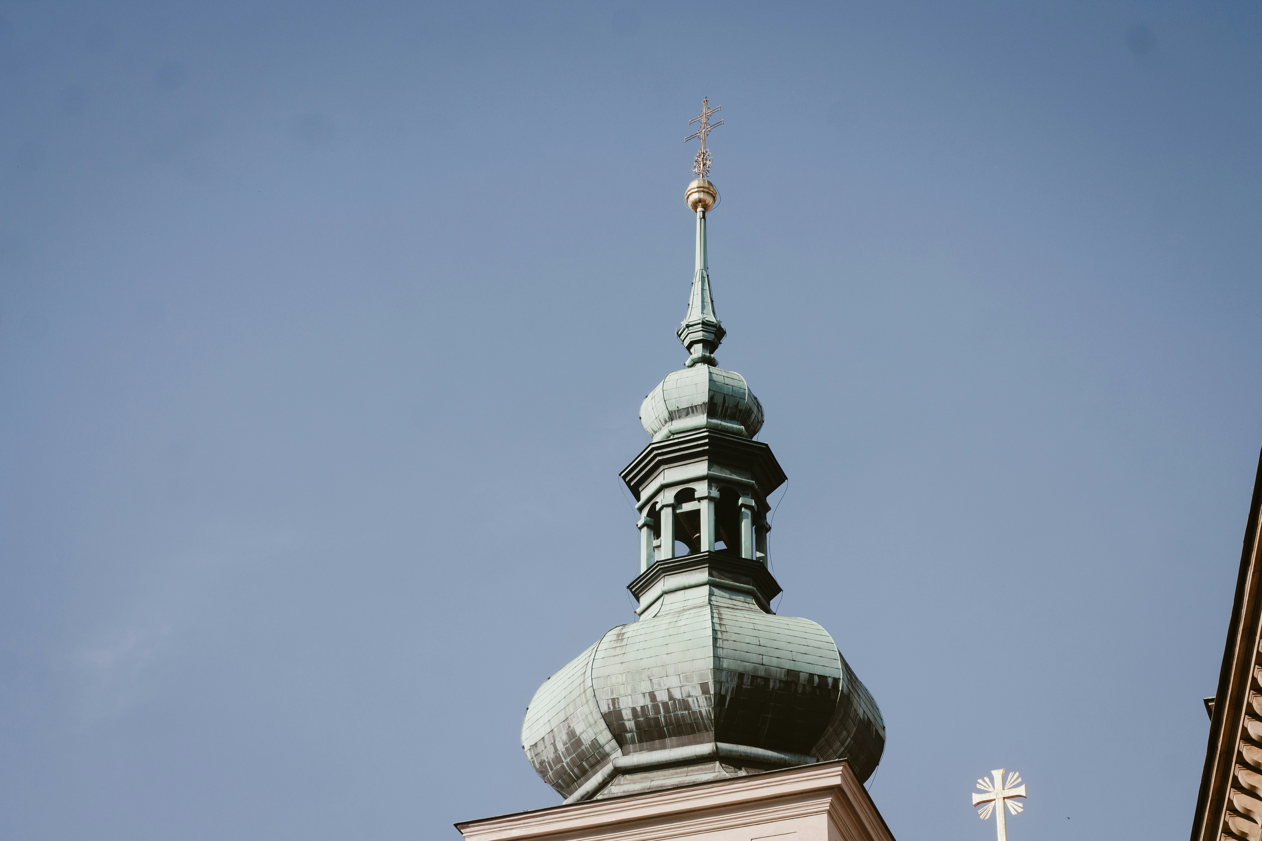 Ornate green dome and spire against a clear blue sky.