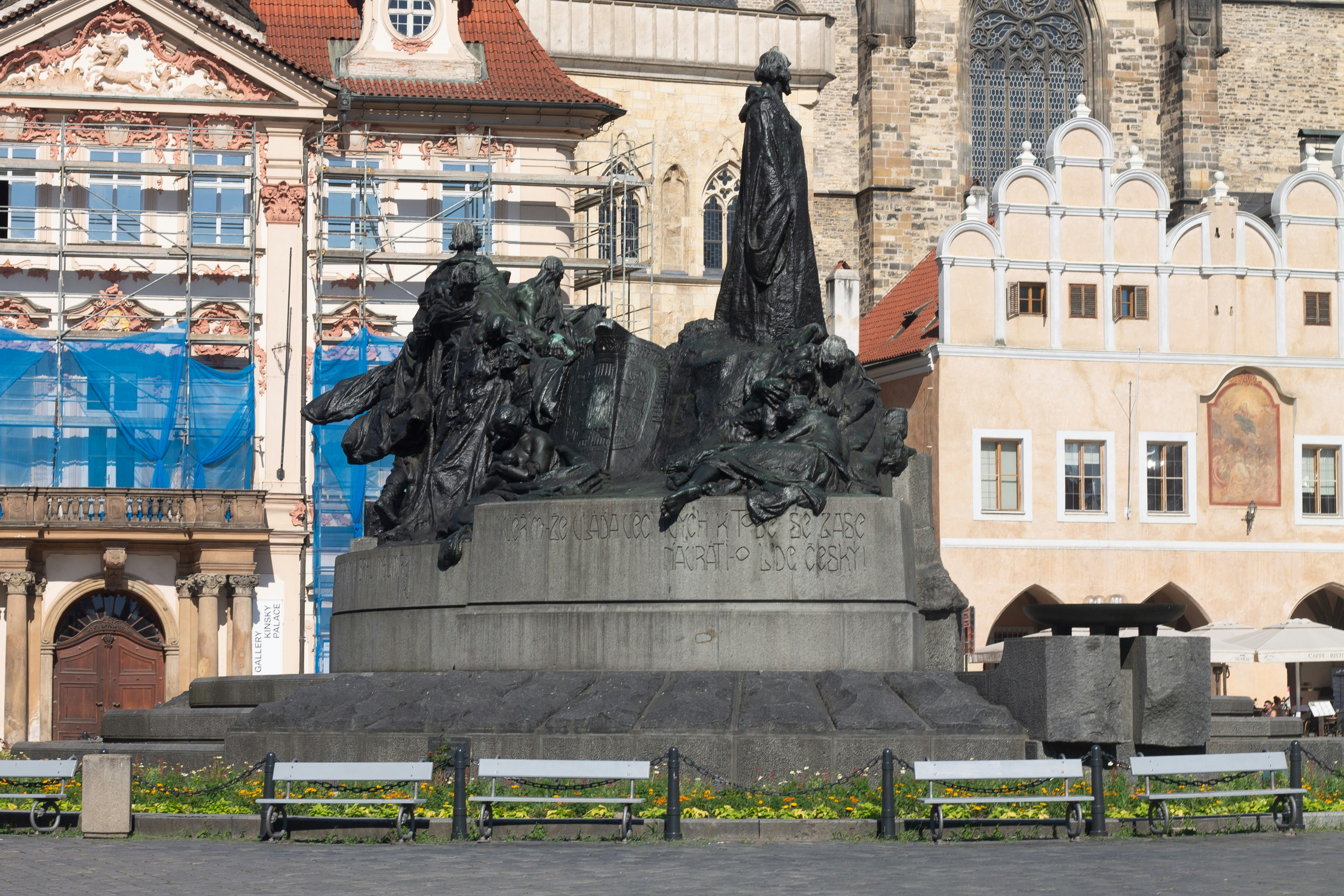A large bronze monument in a historic european city square.