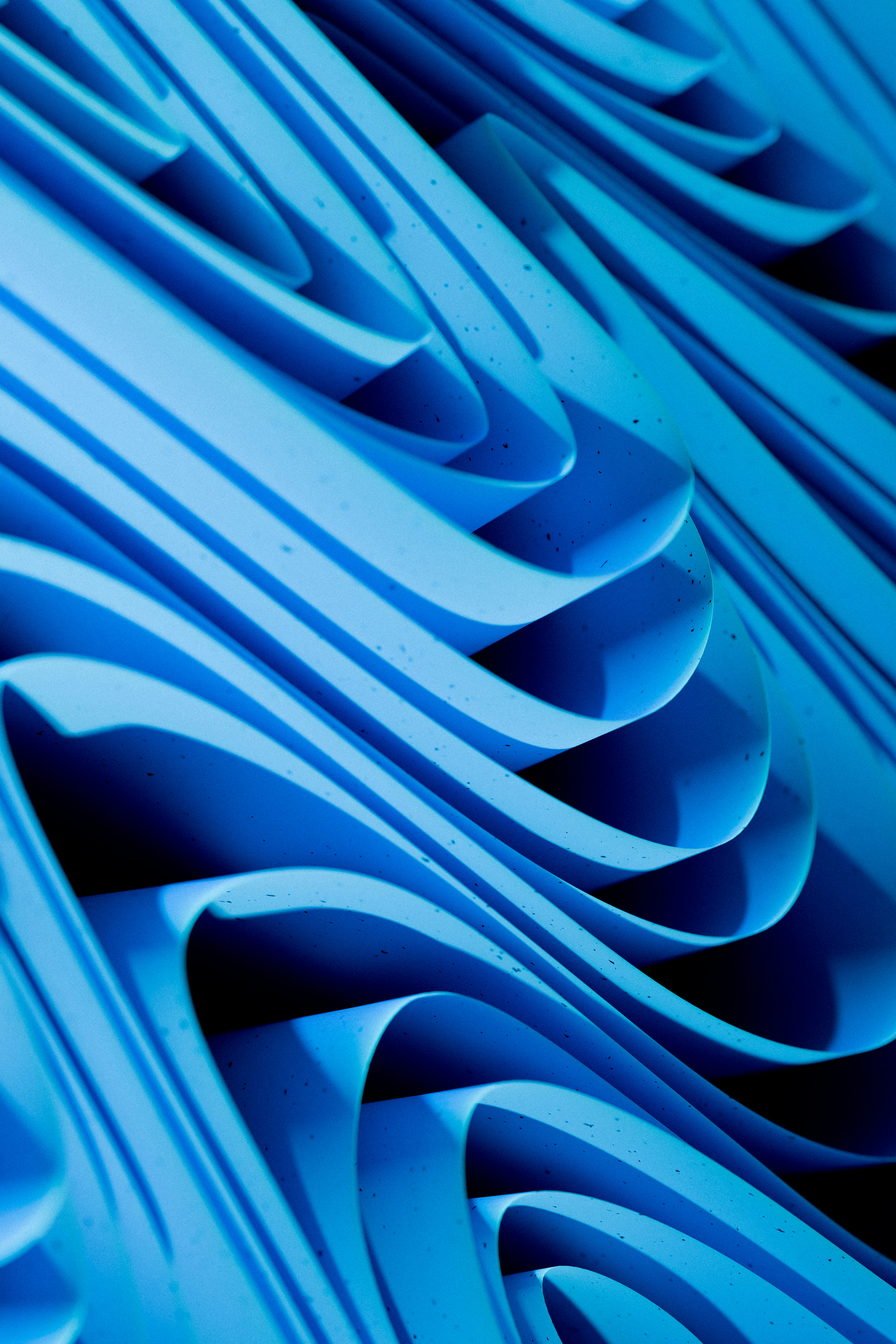 Abstract blue wavy layered shapes create a dynamic pattern.