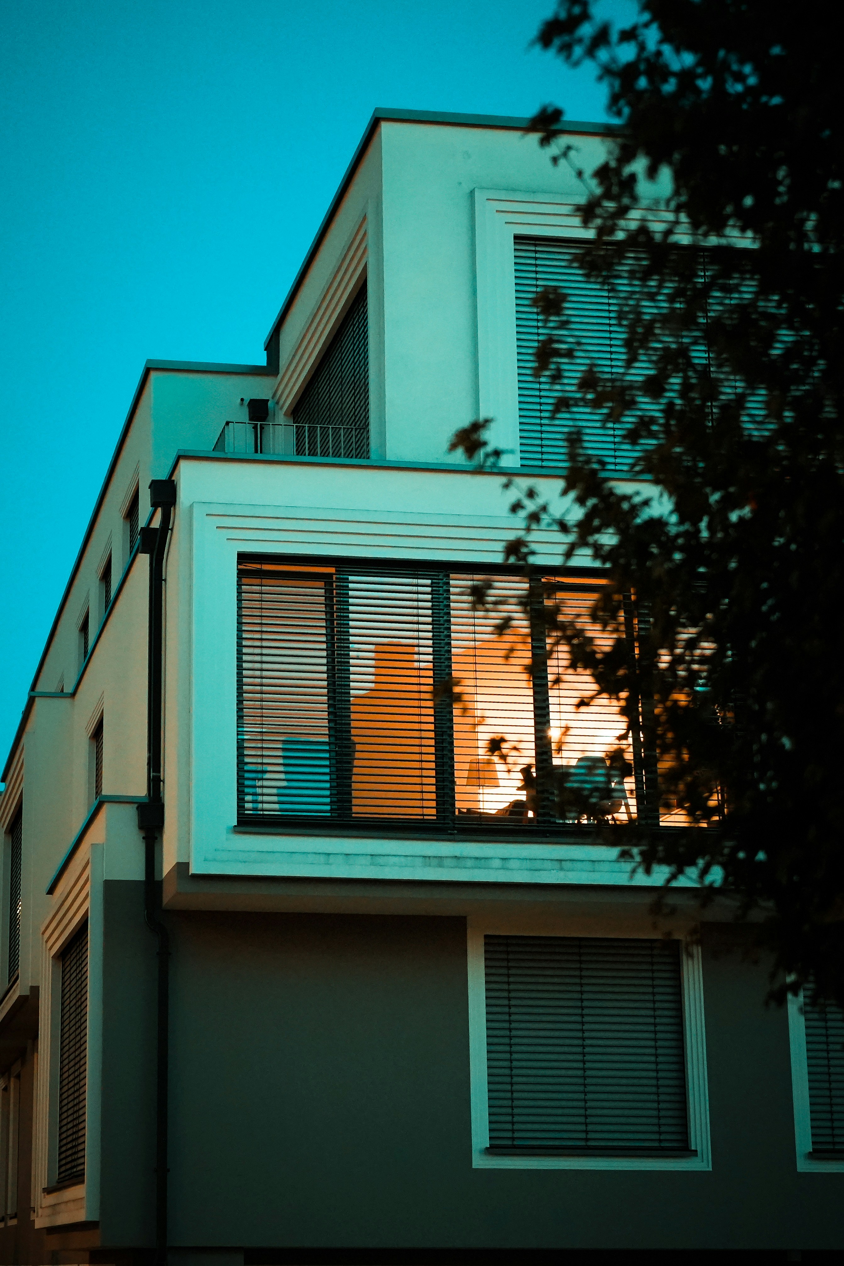 Modern building at dusk with orange window reflection.