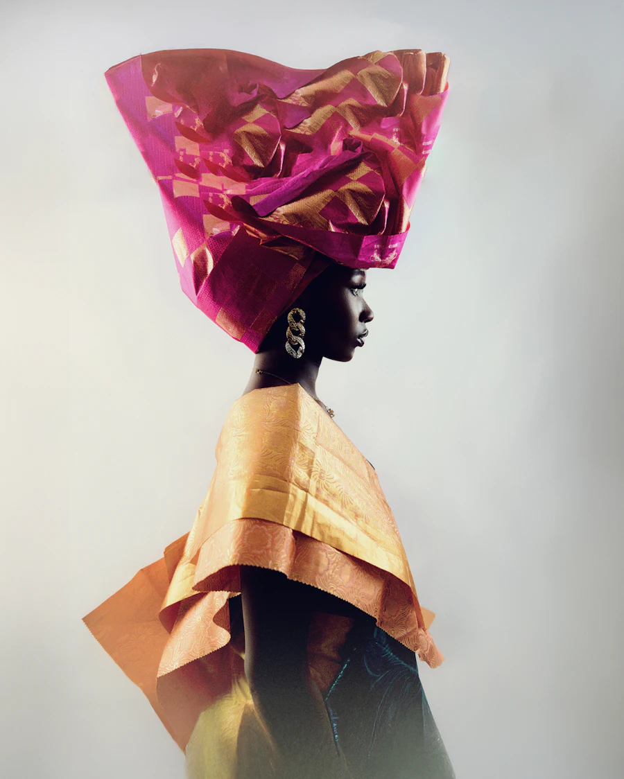 Woman wearing a large pink and gold fan-pleated gele