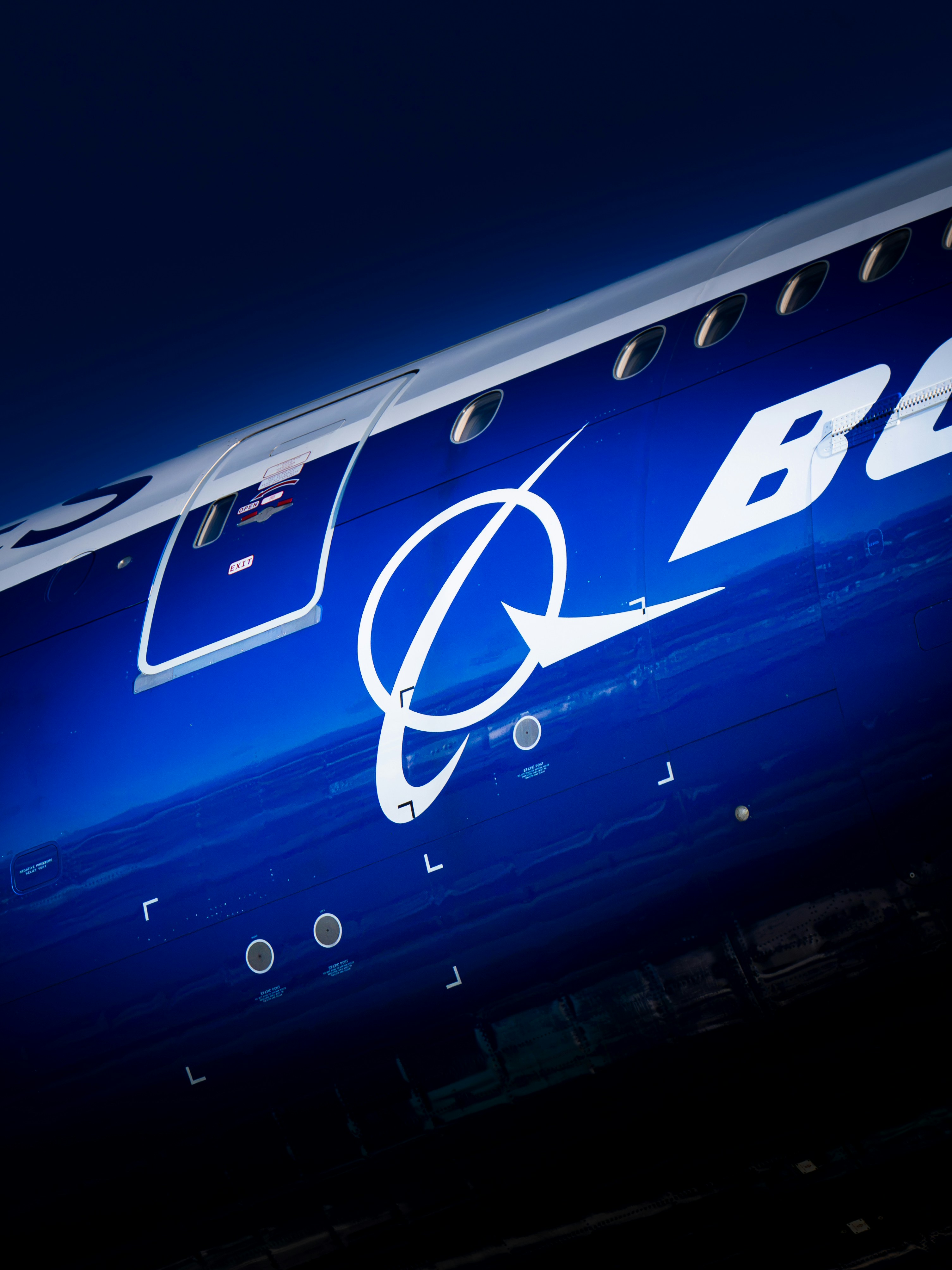 Close-up of the boeing logo on a dark blue airplane.