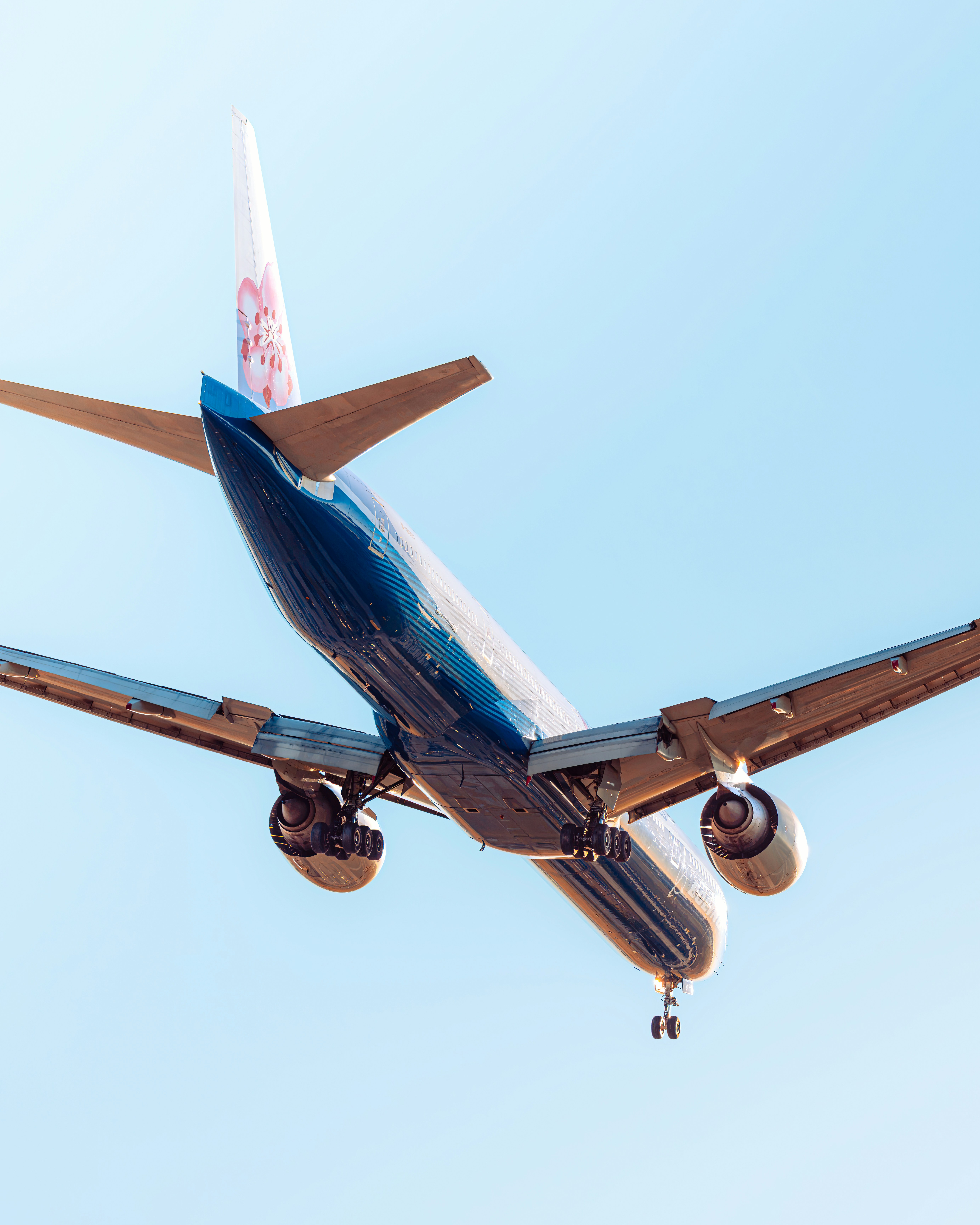 A large passenger airplane flies against a clear blue sky.