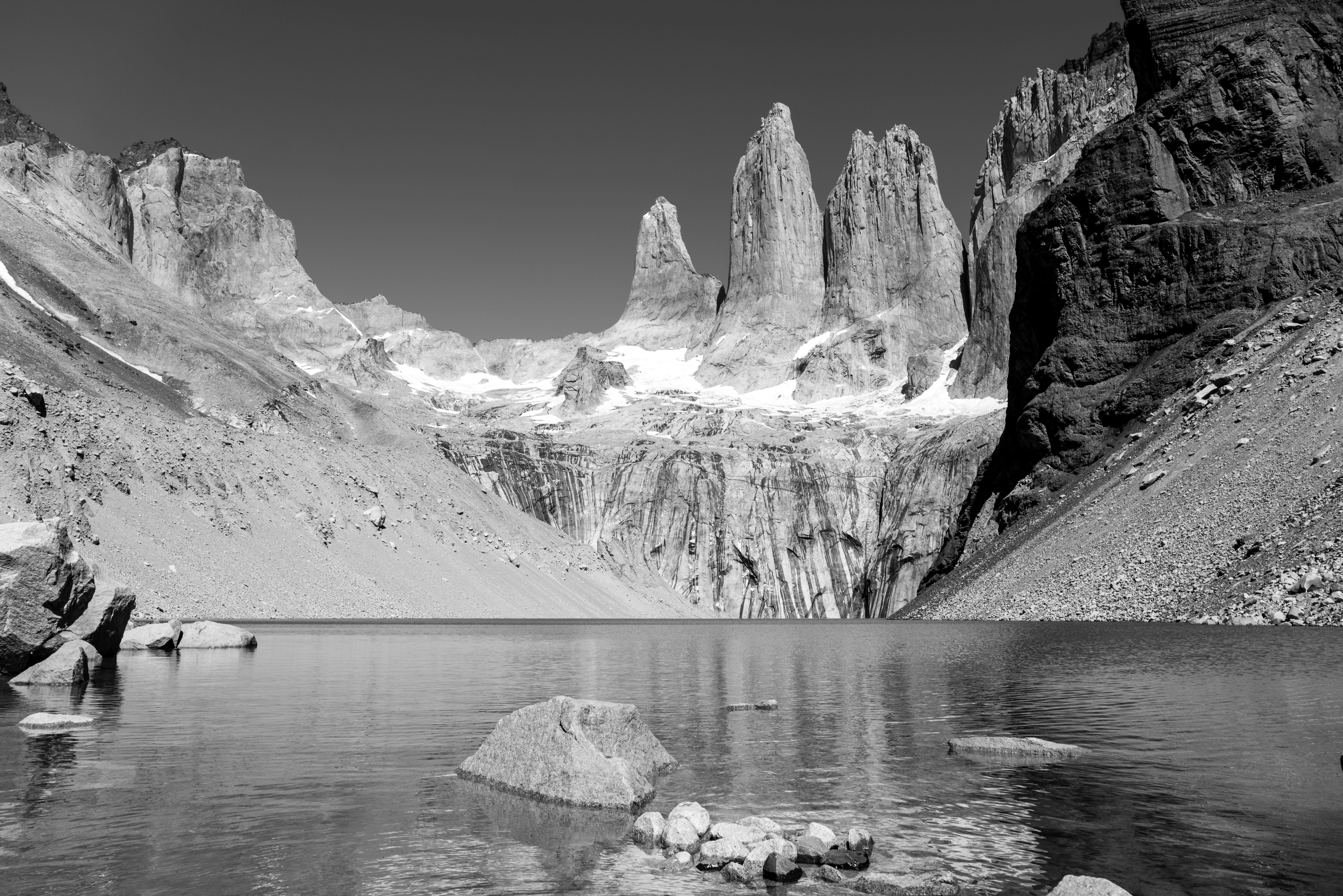 Dramatic mountain spires reflected in a tranquil lake.