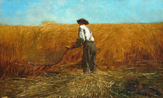 A man harvesting golden wheat with a scythe
