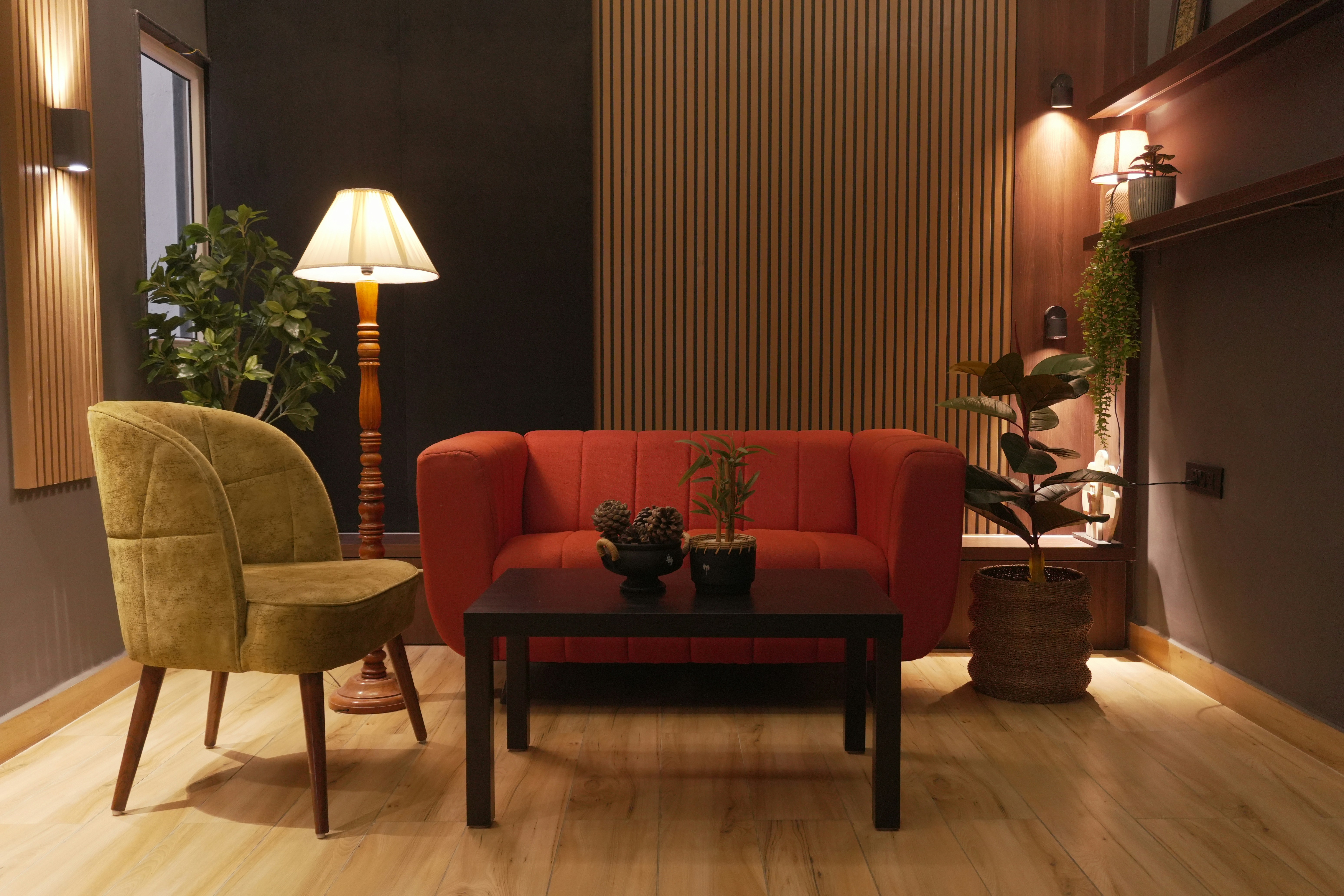 Interior design with red sofa, green armchair, and wooden paneling.