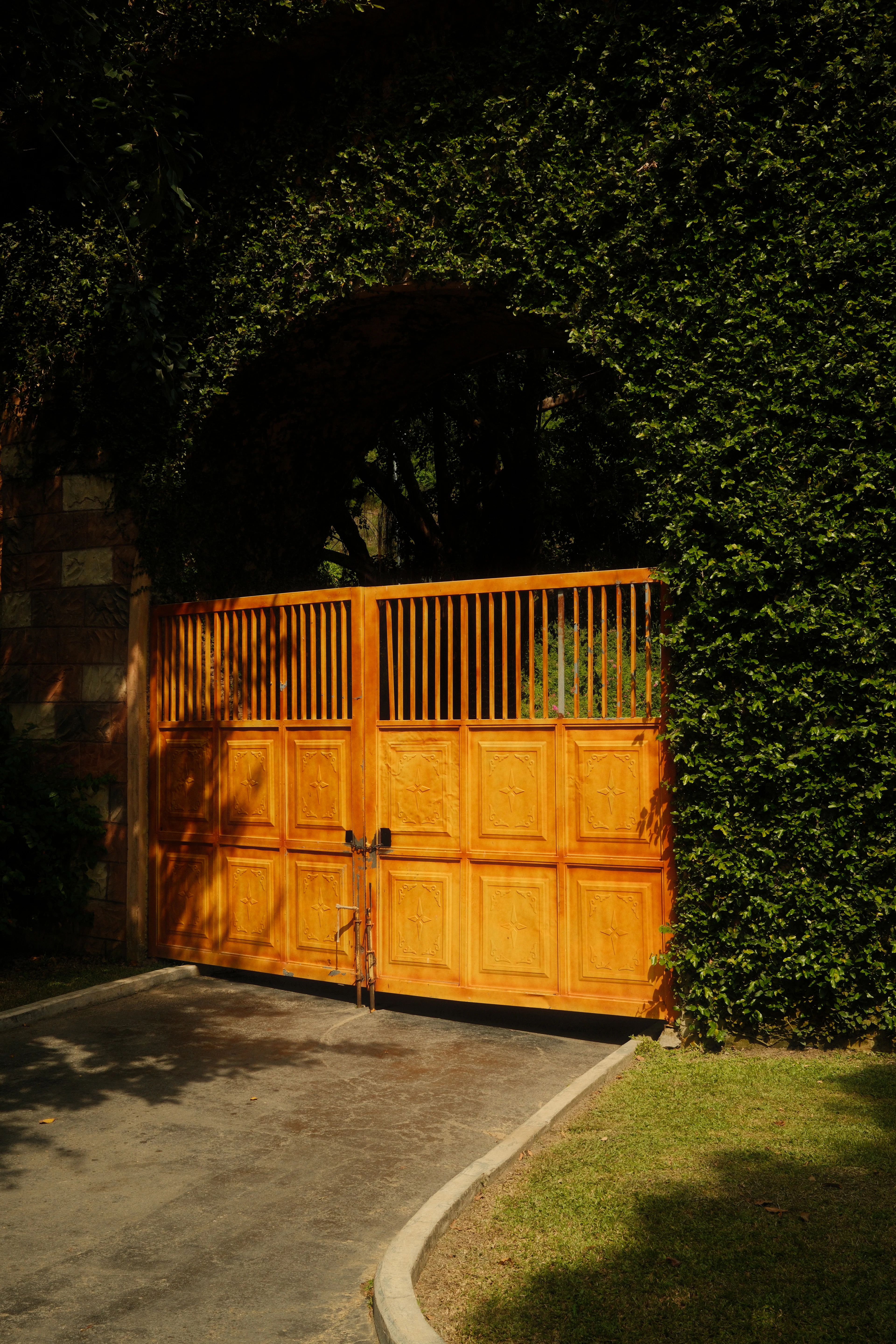 Large wooden gate under a green archway