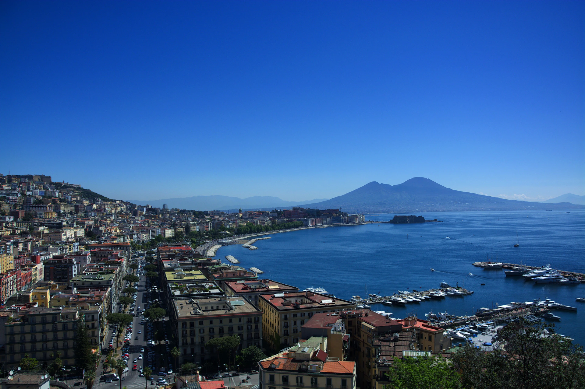Naples cityscape with mount vesuvius overlooking the bay and boats
