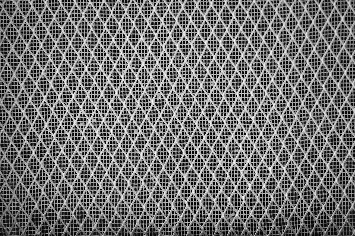Makro kain mesh polyester abu-abu dengan pola lubang ventilasi berbentuk wajik