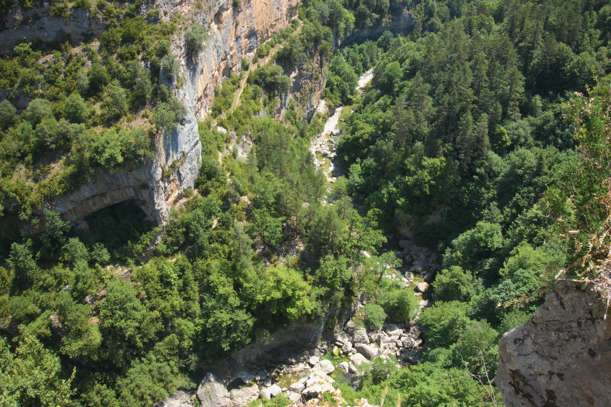 Dry riverbed winding through a rocky canyon with steep cliff walls