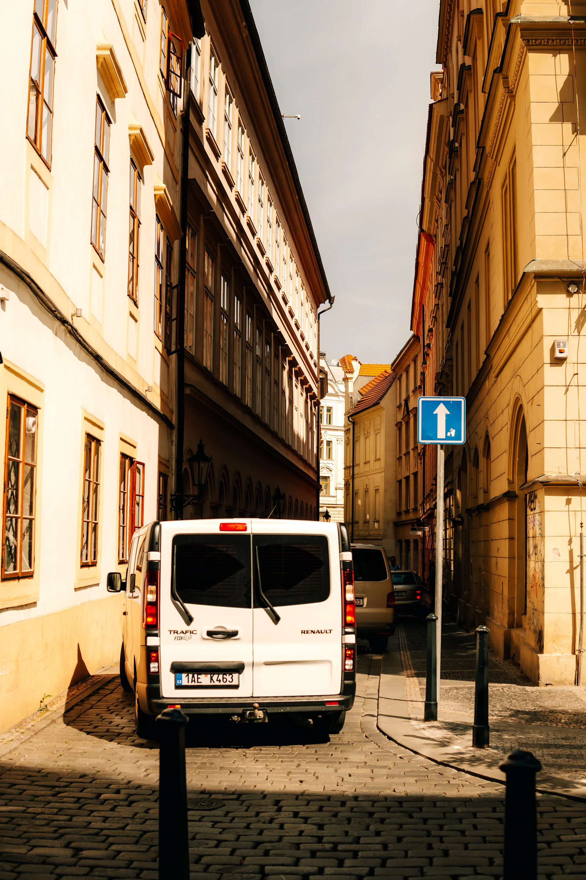 Nowoczesny bus w dynamicznej jeździe wąską uliczką europejskiego starego miasta o złotej godzinie