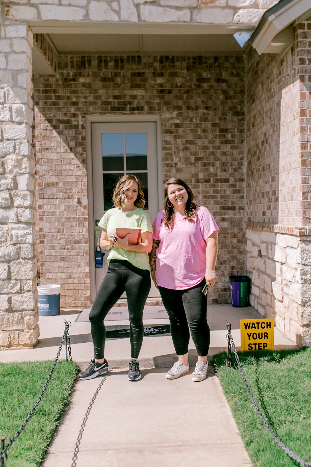 Happy homeowners smiling at their front porch