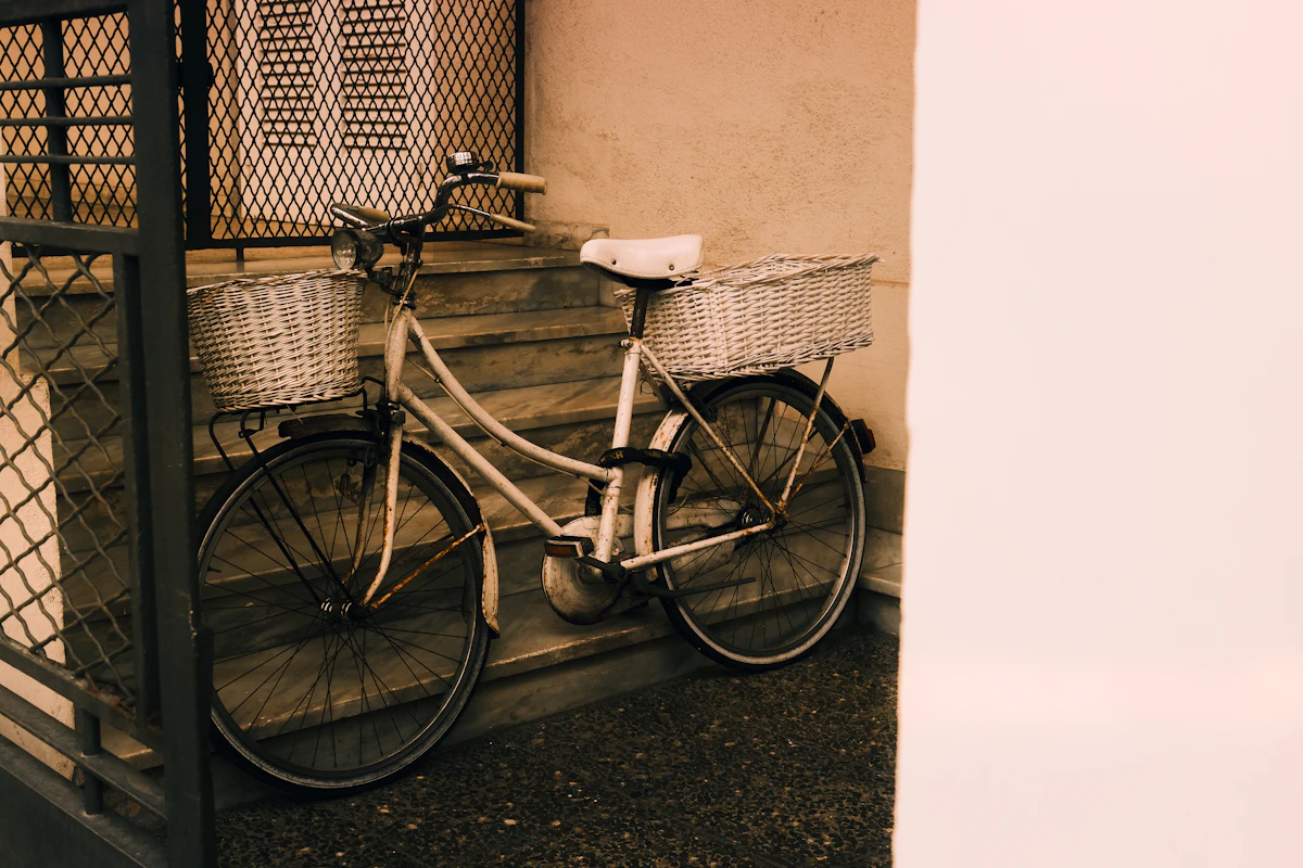 Vintage bicycle with two wicker baskets leaning against stairs