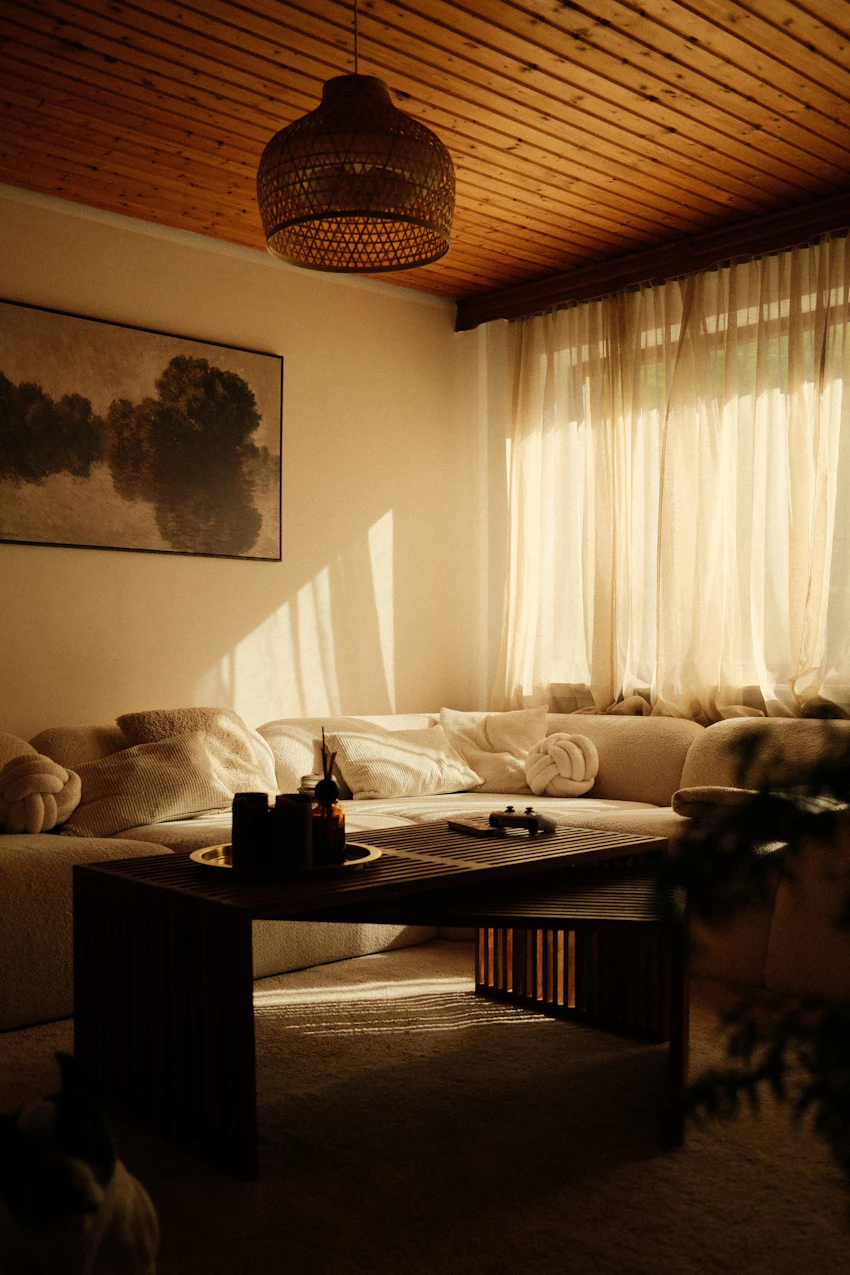 Luz de fim de tarde sobre sofá claro e mesa de madeira