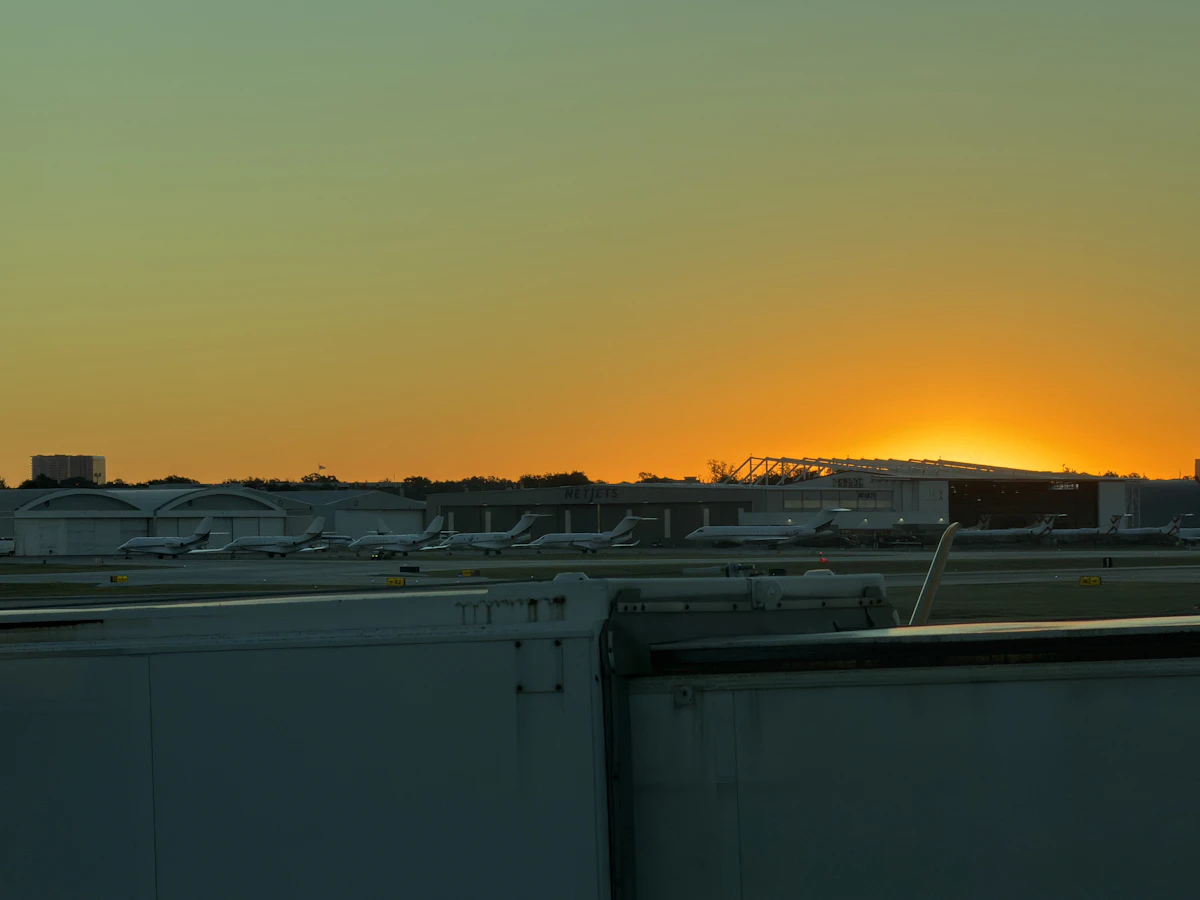 Airplane parked at an airport gate at sunset