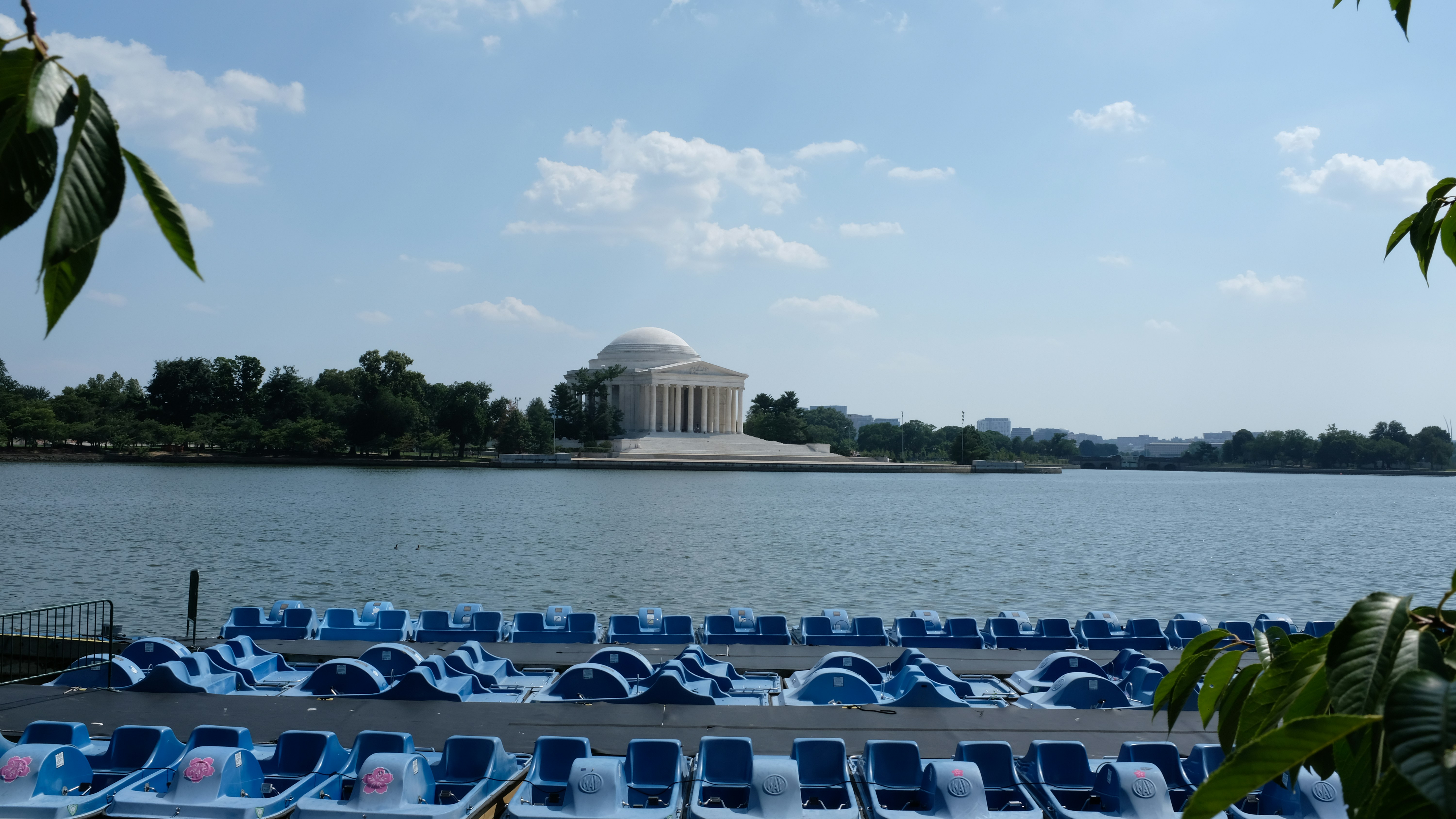 The jefferson memorial across the tidal basin with paddle boats.