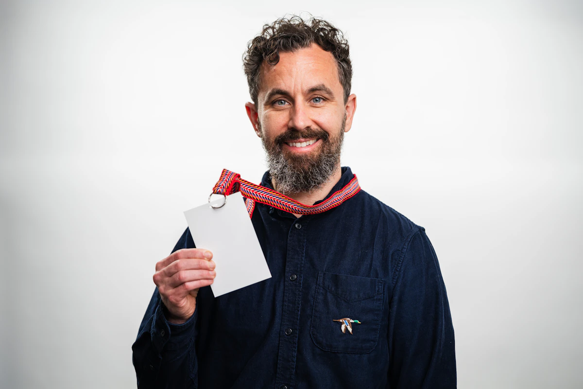 Man holding a blank white badge