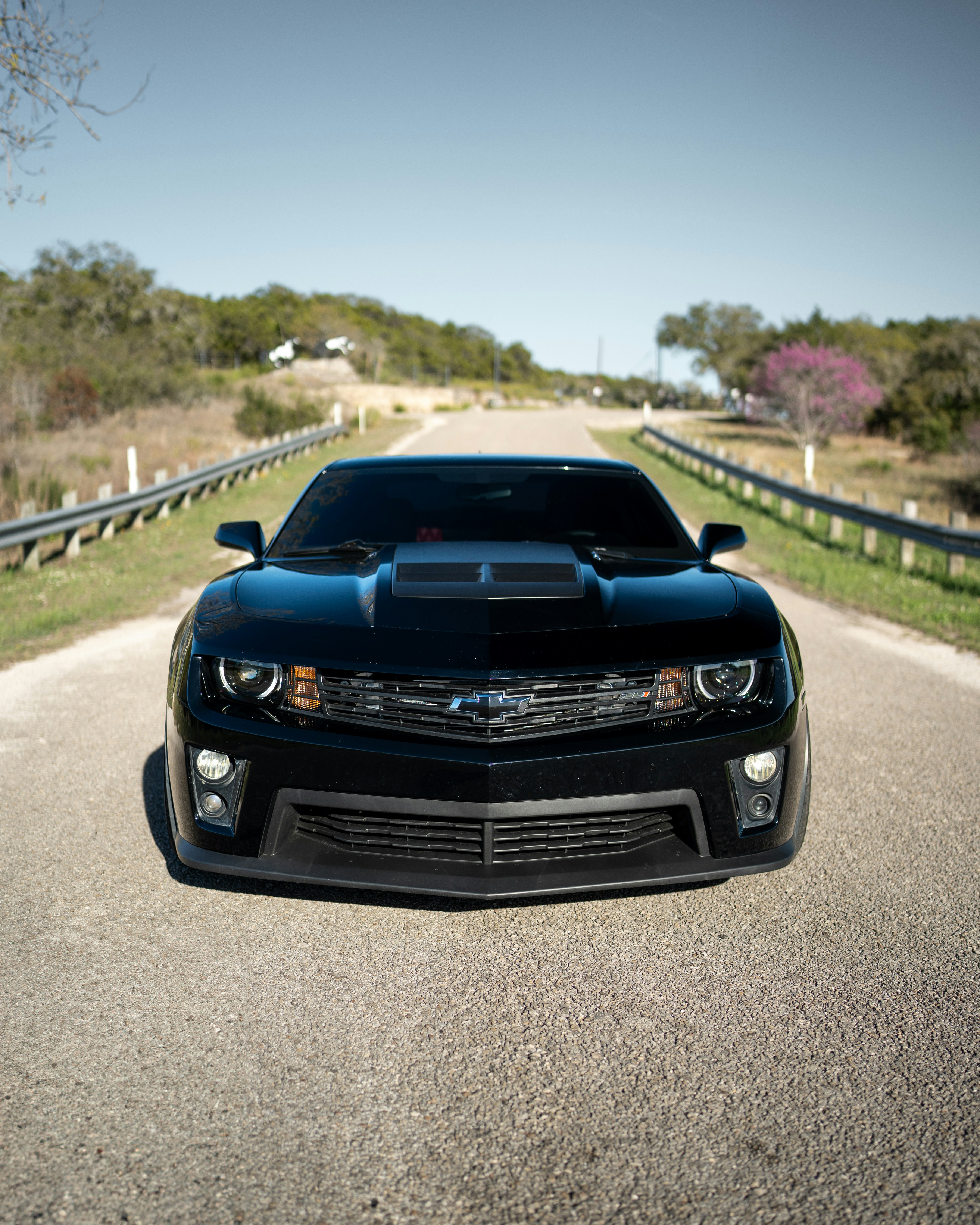 A black chevrolet camaro parked on an empty road