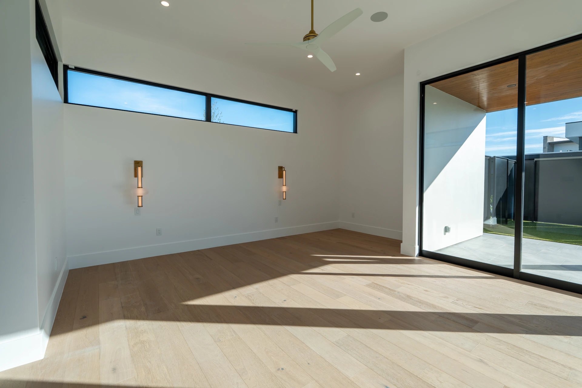 Bright empty room with hardwood floors and large windows