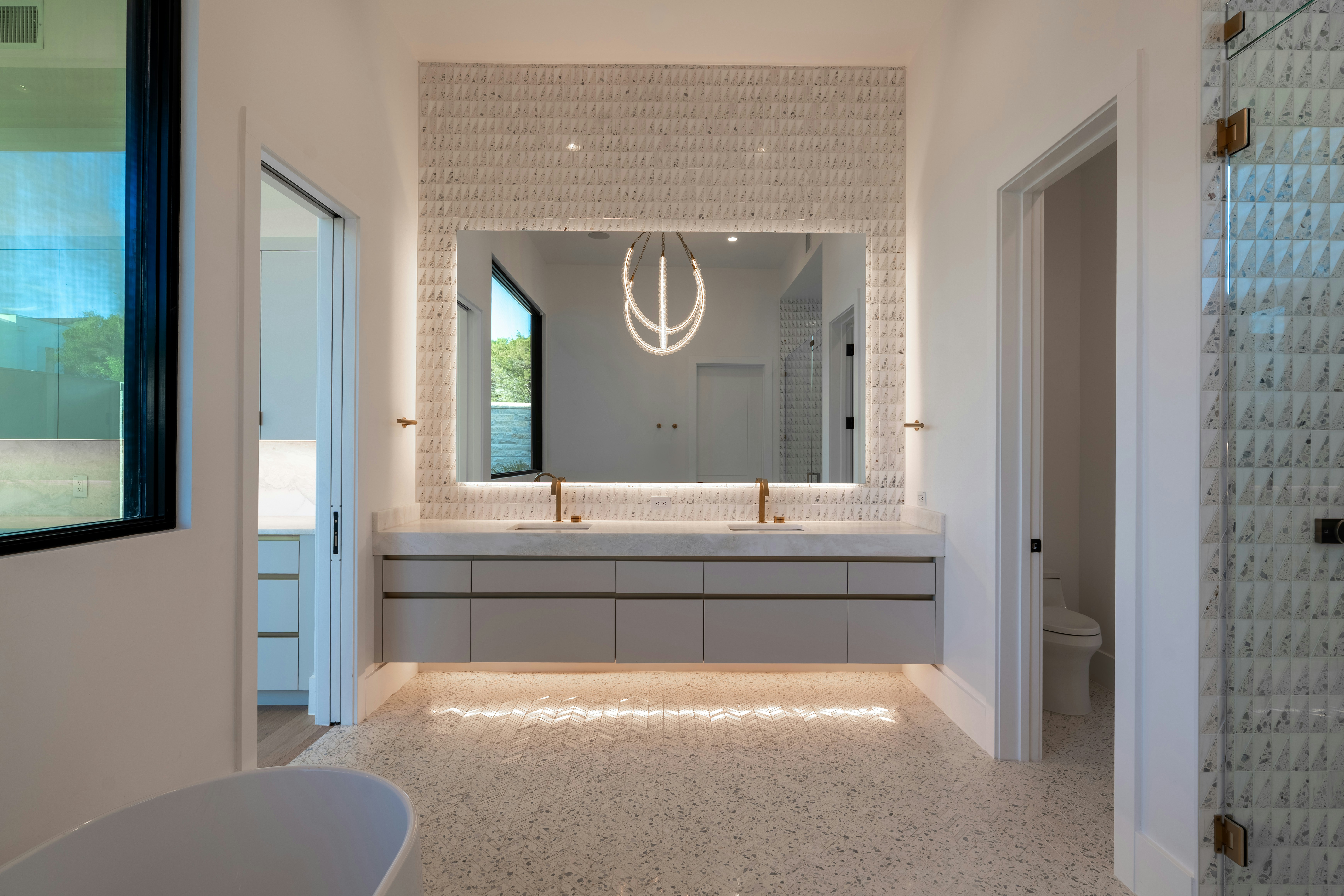 Elegant modern bathroom with large illuminated mirror and double vanity.
