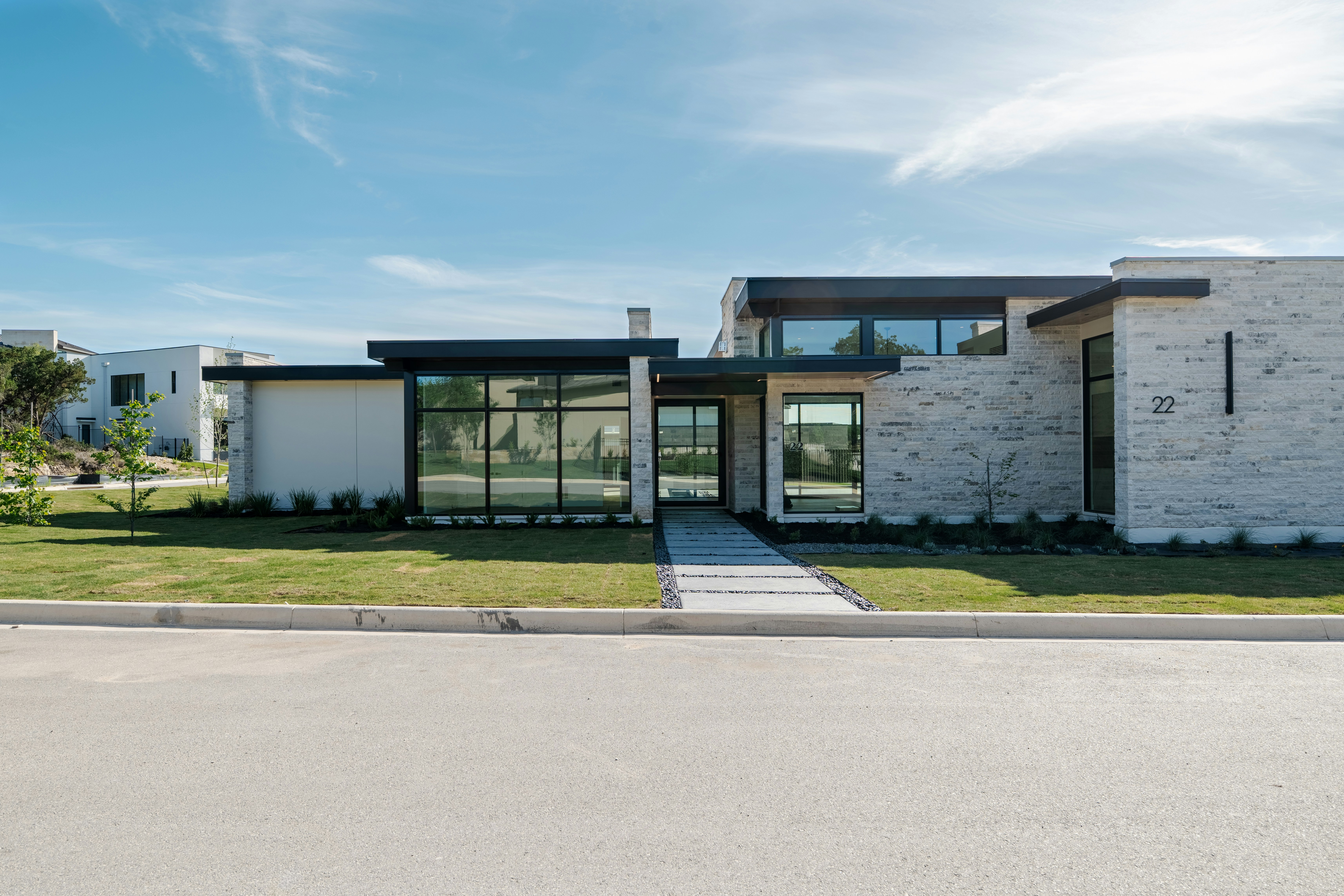 A modern house with large windows and a green lawn