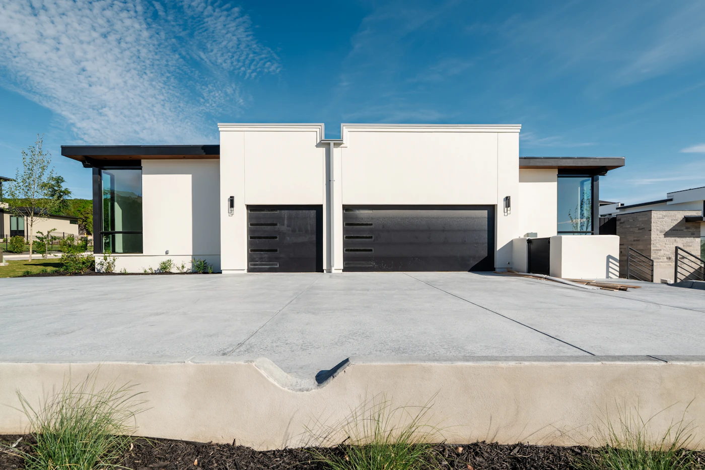 Contemporary white homes with black garage doors