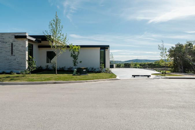 A modern luxury house with a manicured lawn and wide driveway, typical of high end master planned community construction