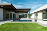 A modern house with a swimming pool and green lawn.