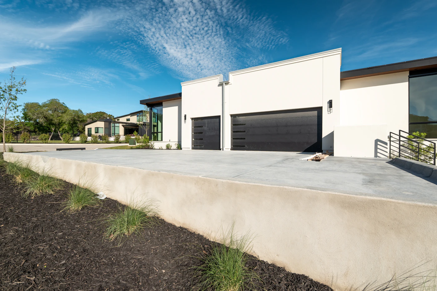 Modern house exterior with two black garage doors
