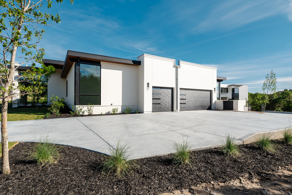 A concrete driveway in front of a two-car garage