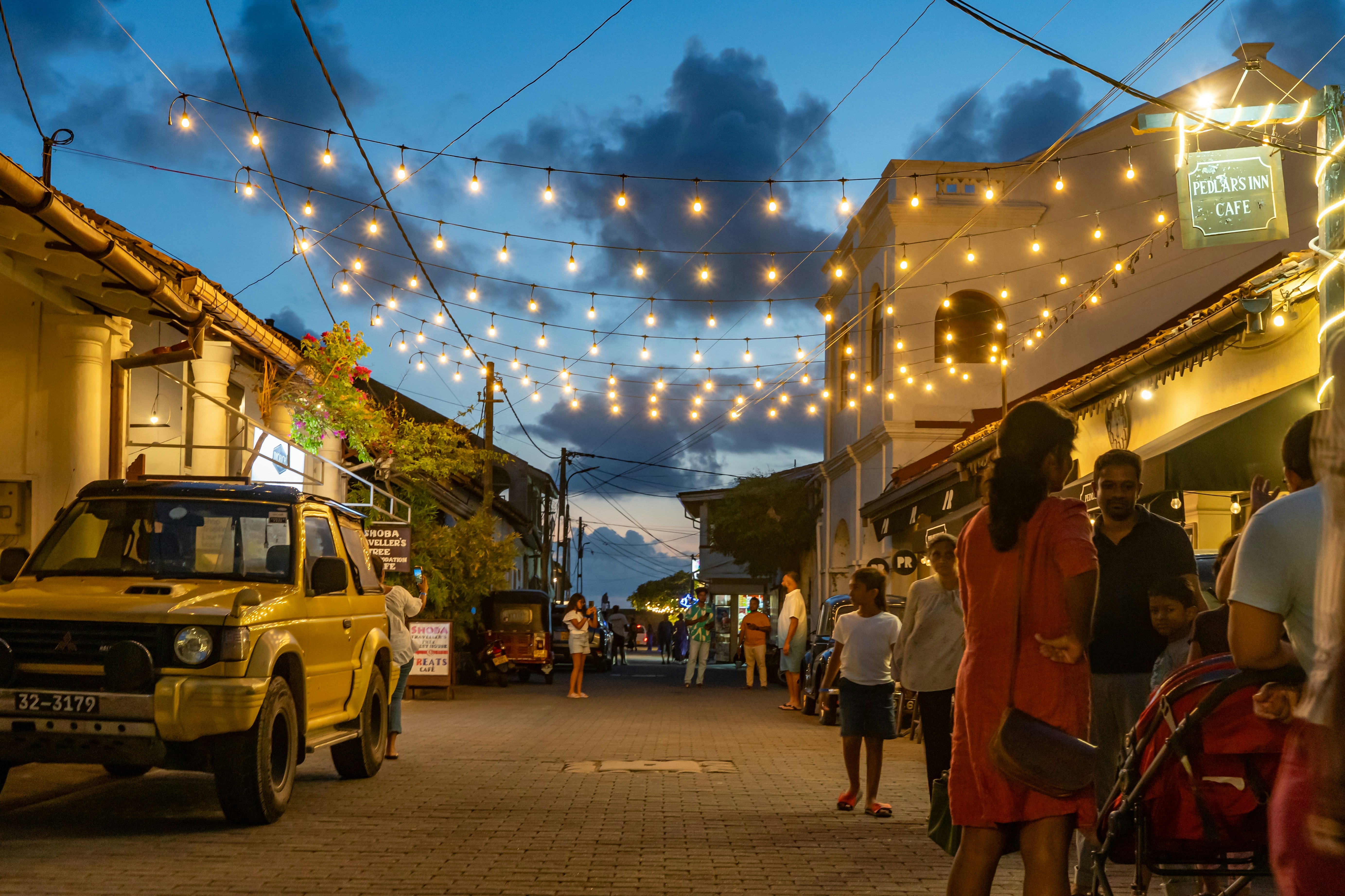 Lively street at dusk under festoon lights