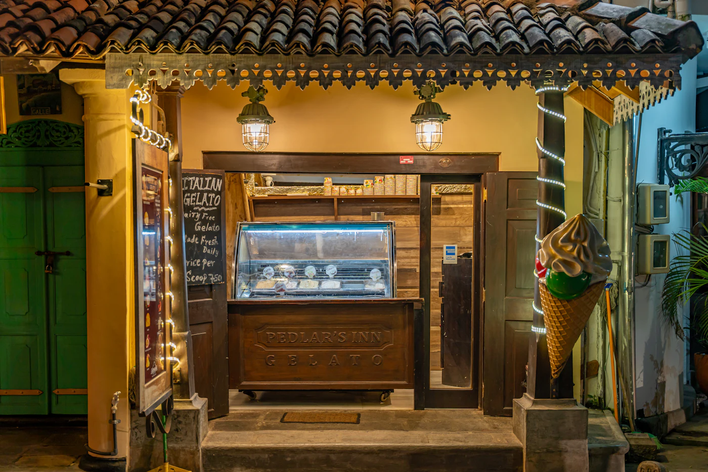 The wooden shopfront of a small ice cream shop, lit from inside
