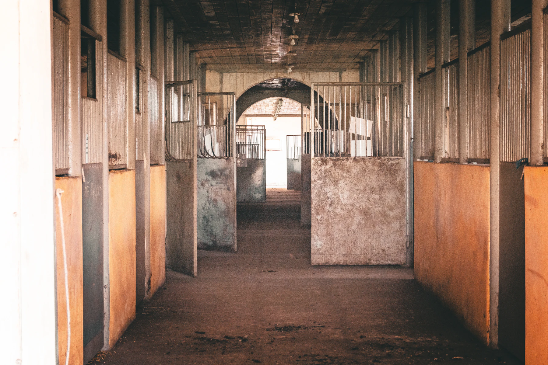 A rustic British stable corridor with open stalls