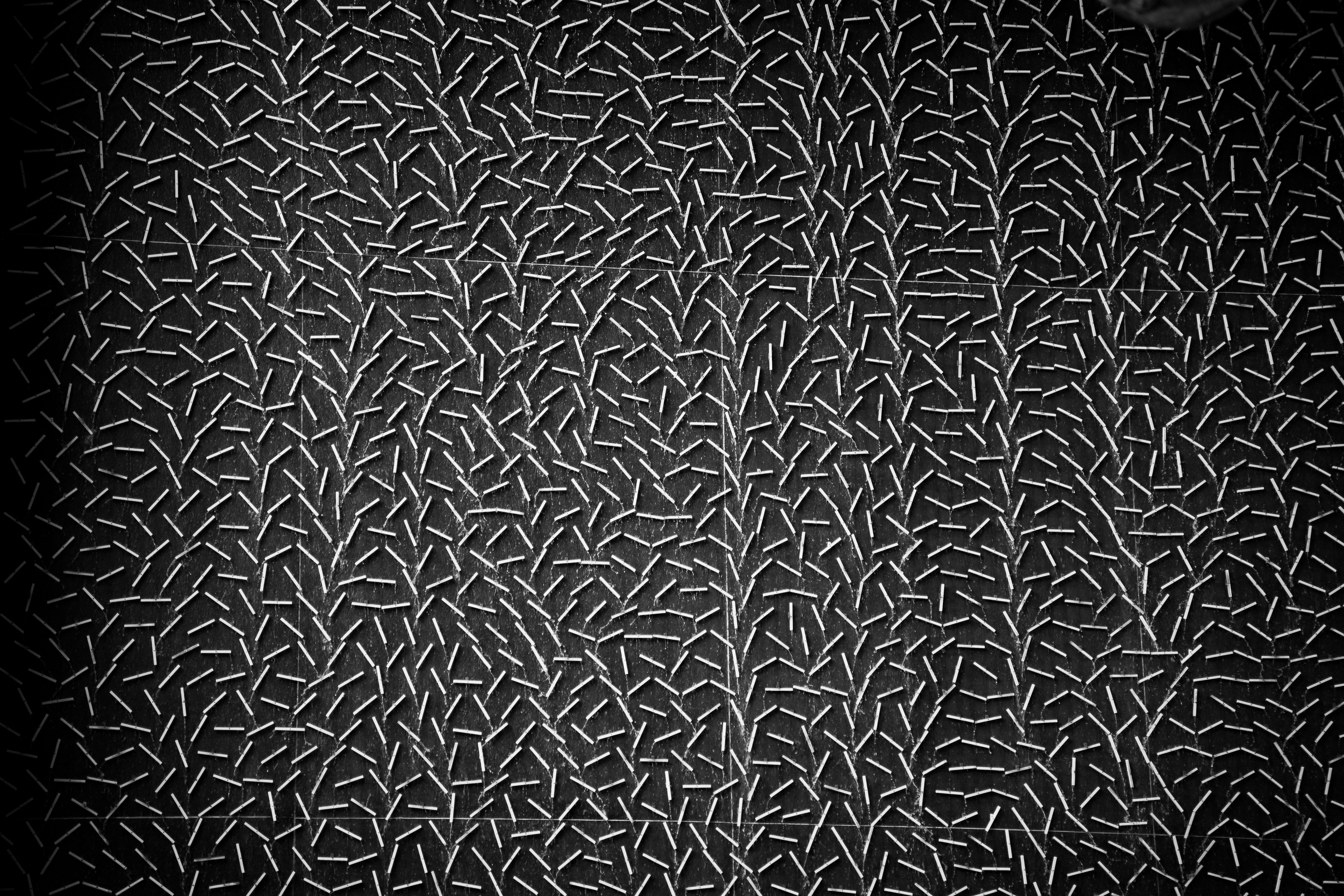 Dark textured surface with intricate, light-colored abstract pattern