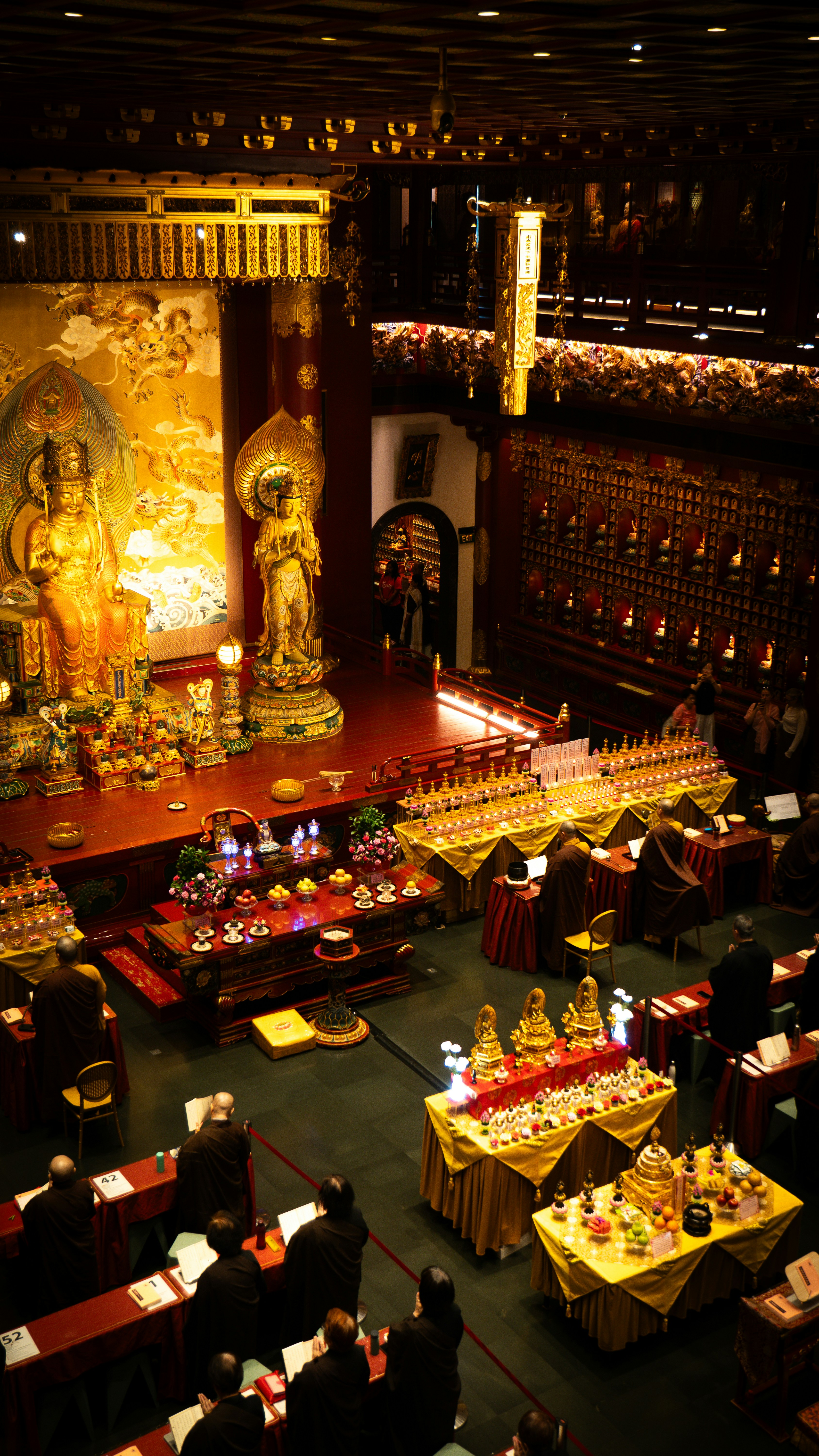 Buddhist temple interior with golden statues and seated worshippers