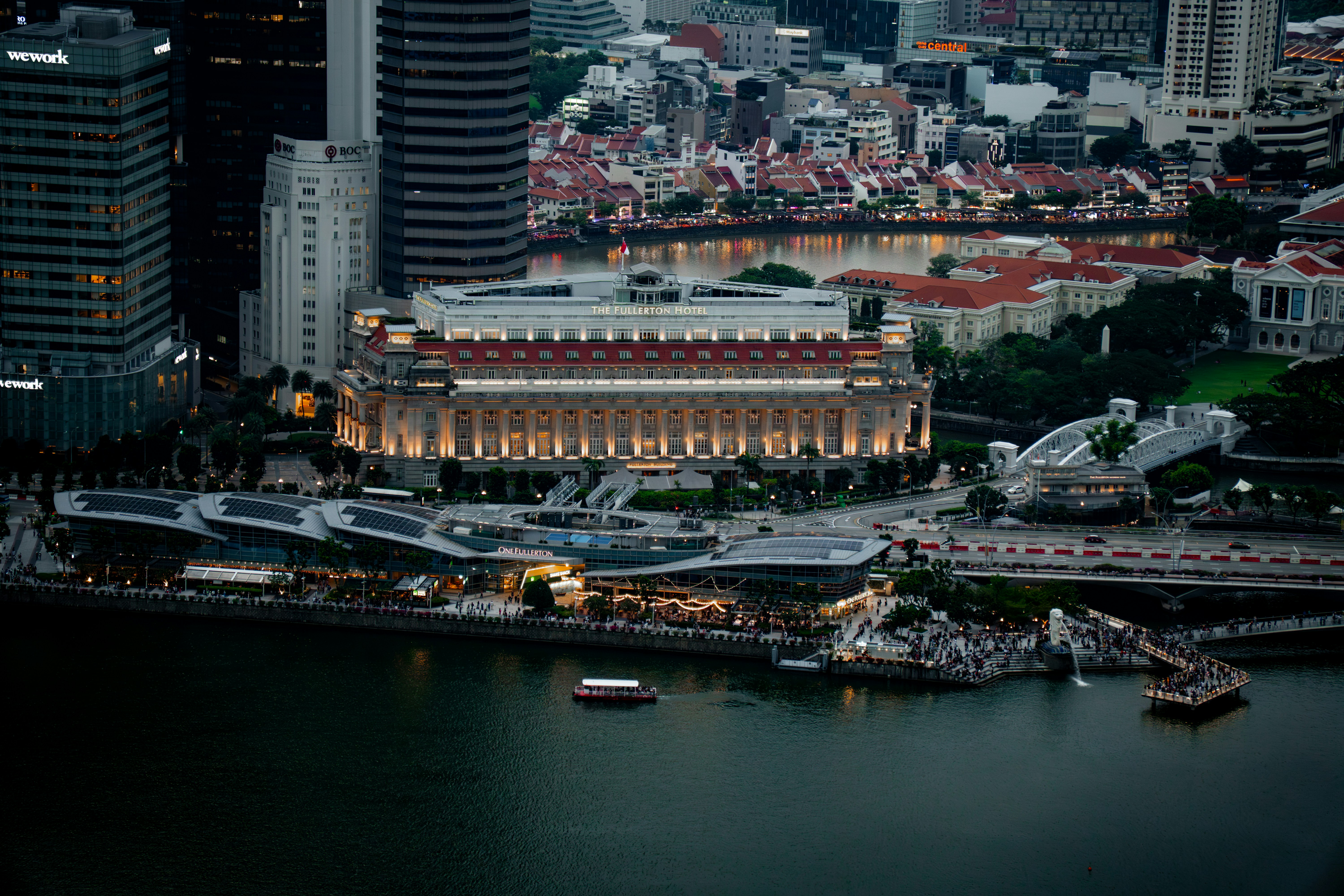 Illuminated historic building by a river in a vibrant city.